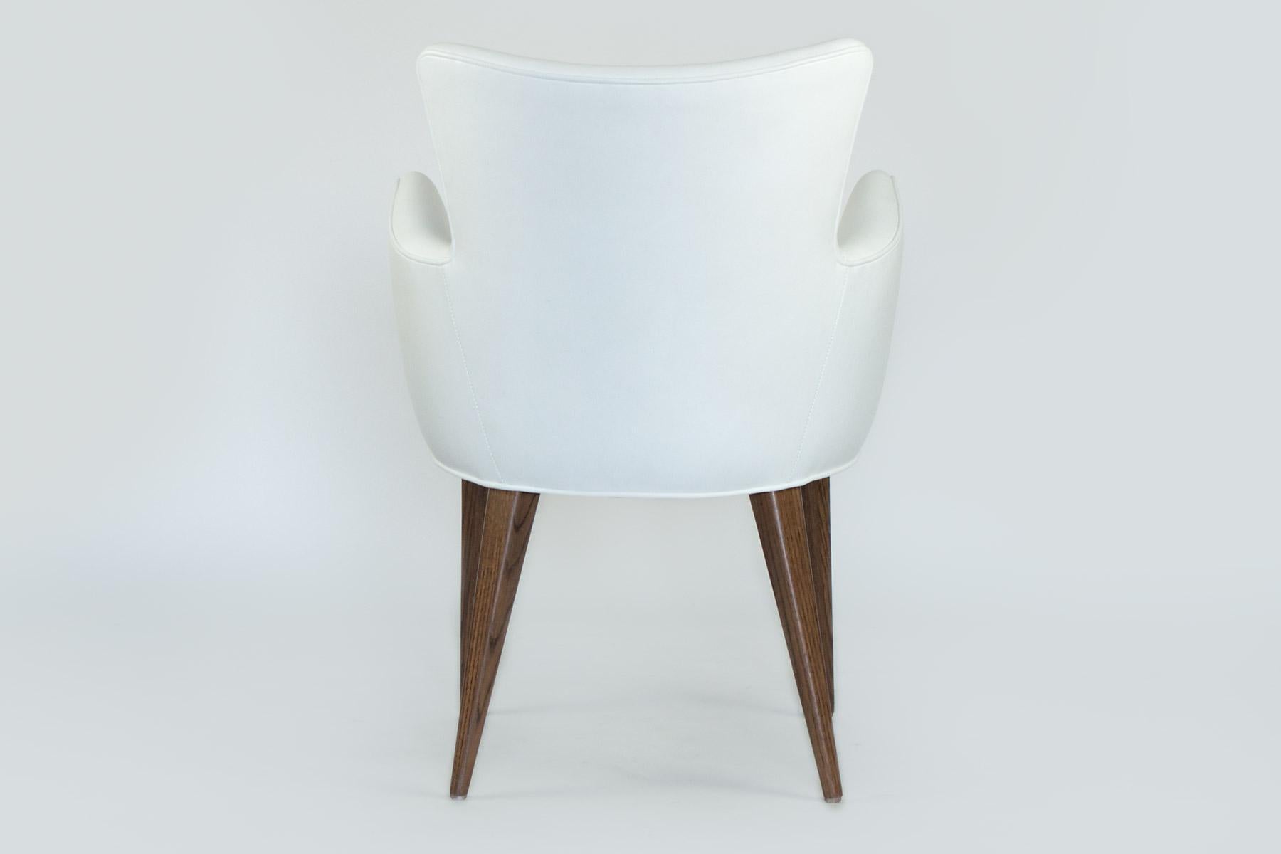 Cette chaise élégante peut être utilisée seule comme chaise d'appoint ou est parfaite dans la salle à manger. Ses lignes sont modernes, mais ses pieds en chêne s'harmonisent avec tous les meubles en bois. Le cadre incurvé vous entoure