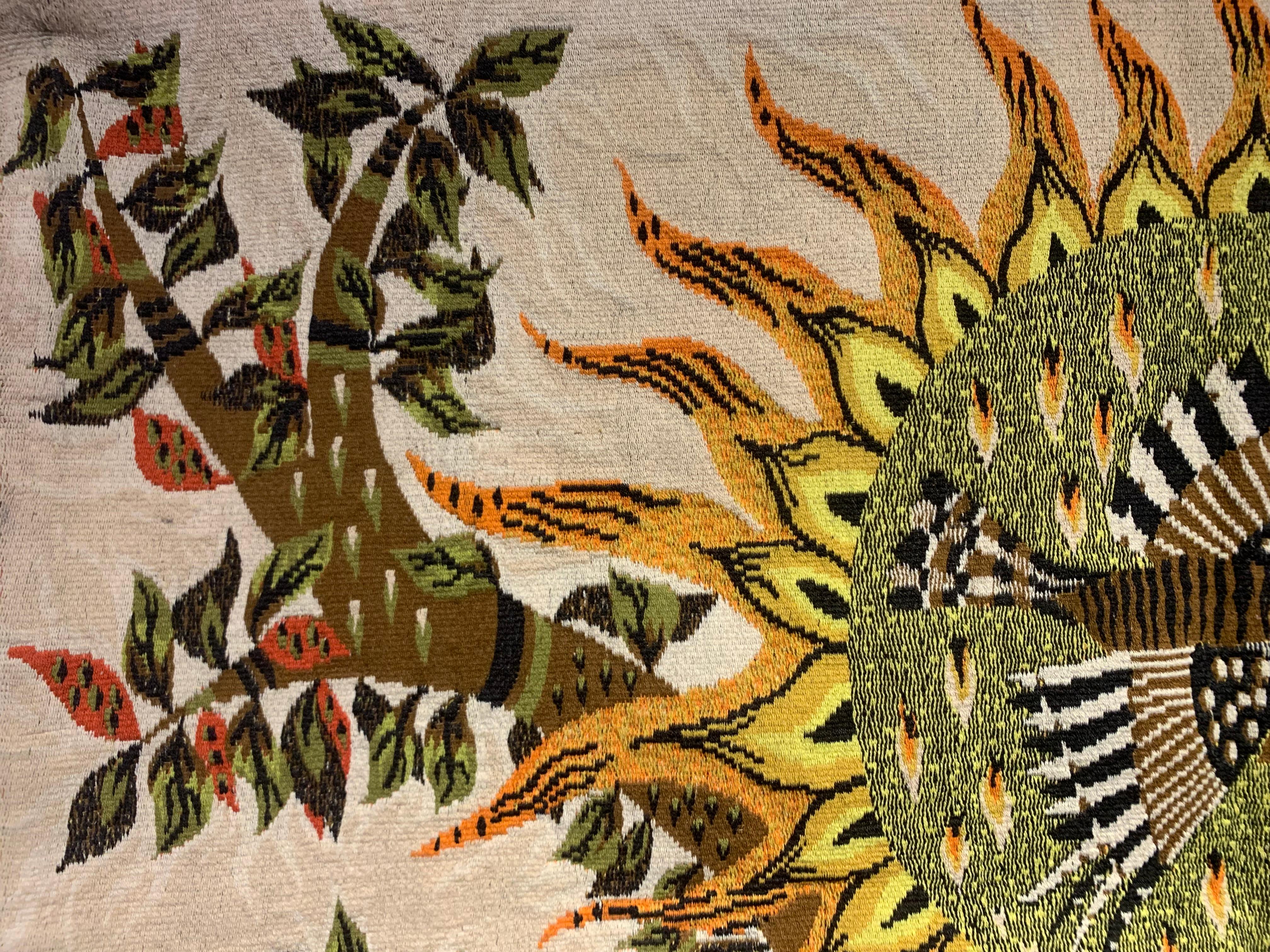 Decorative vintage tapestry signed M.Ray.
Entitled ‘Aube’. Woven wool signed by the artist in the lower right corner. 
Depicting a nature scene, using earthly colors, of trees with a beautiful bird flying around the sun.
Dimensions: W 145 cm, H