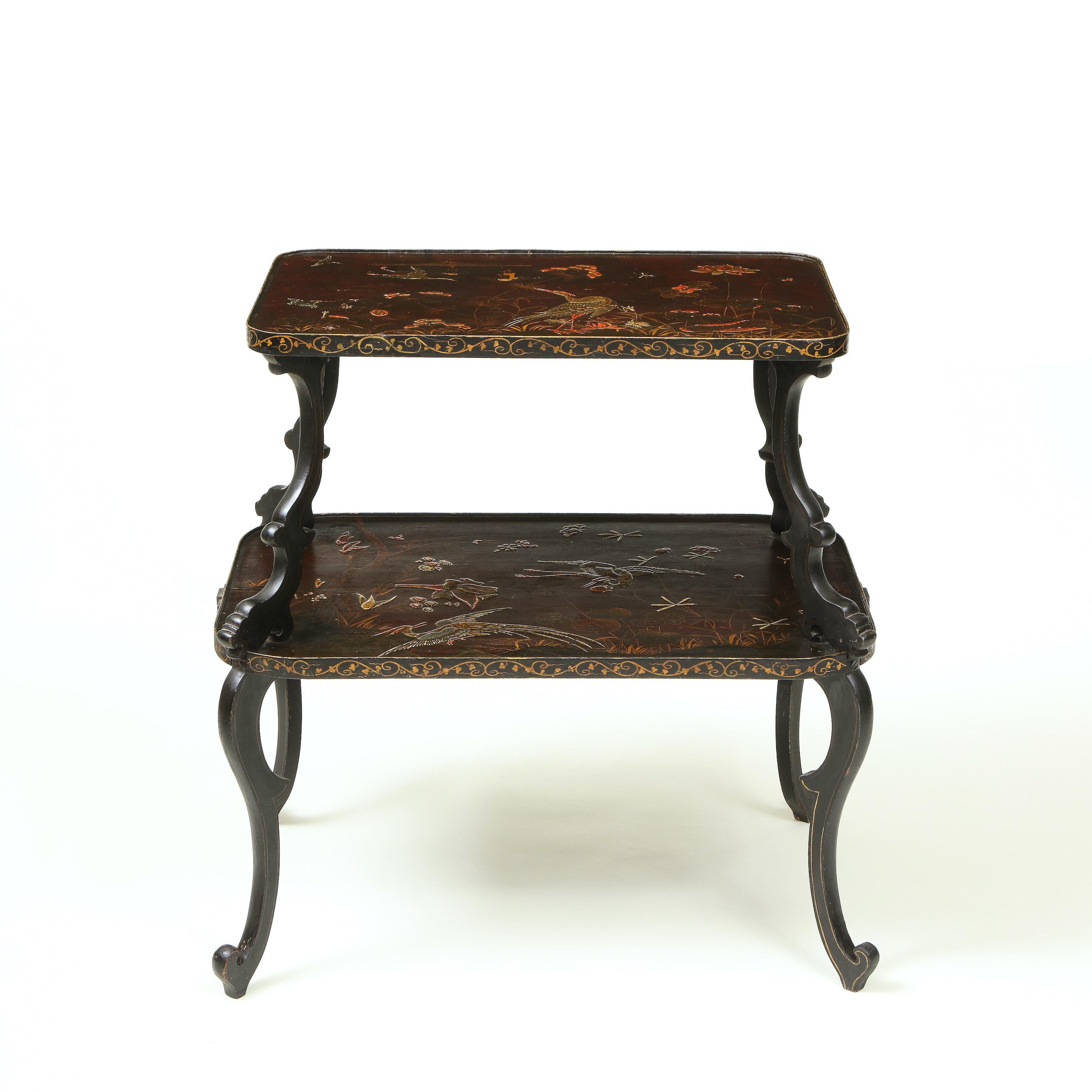 With two rectangular aubergine-ground graduated table tops each japanned with bird and floral decoration, with gilt vine garlands on the edges; on ebonized scroll-form supports.

Provenance: From the Collection of Mario Buatta, New York, NY