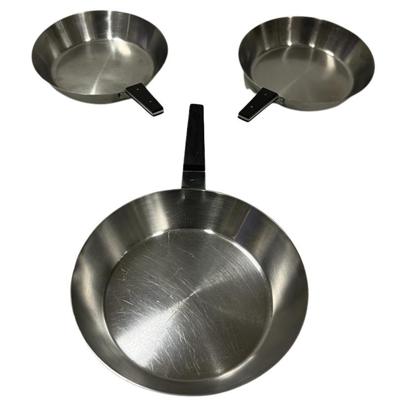 Auböck stainless steel pans, Amboss, Vienna Austria 1965, the two small pans are in good used condition. The third large pan has a small crack in the handle.
