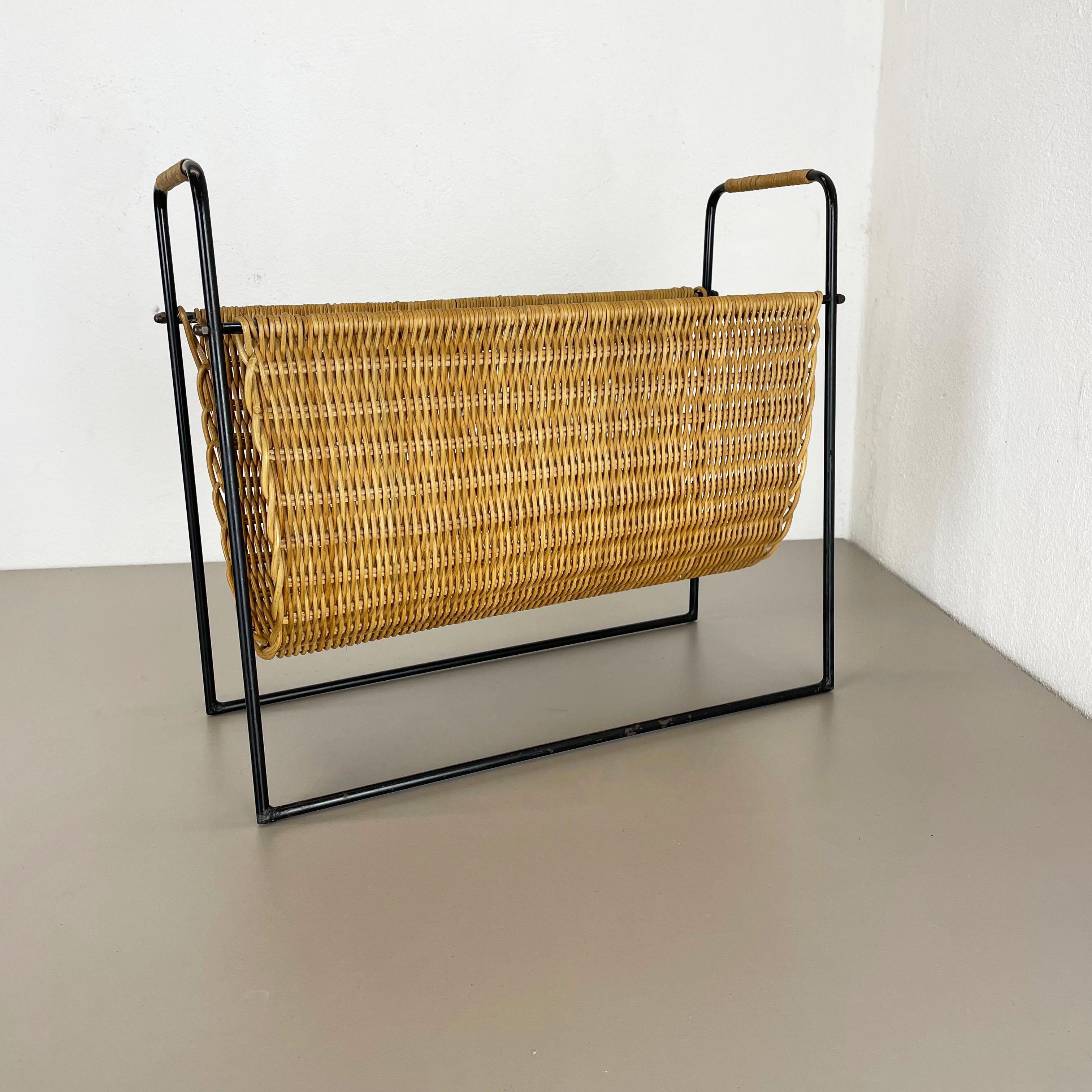Article: magazine holder stand element

Origin: France

Age: 1970s

This original vintage Bauhaus style magazine holder stand was produced in the 1950s in France. It is made of natural rattan in a oval formed shape and at the top left and