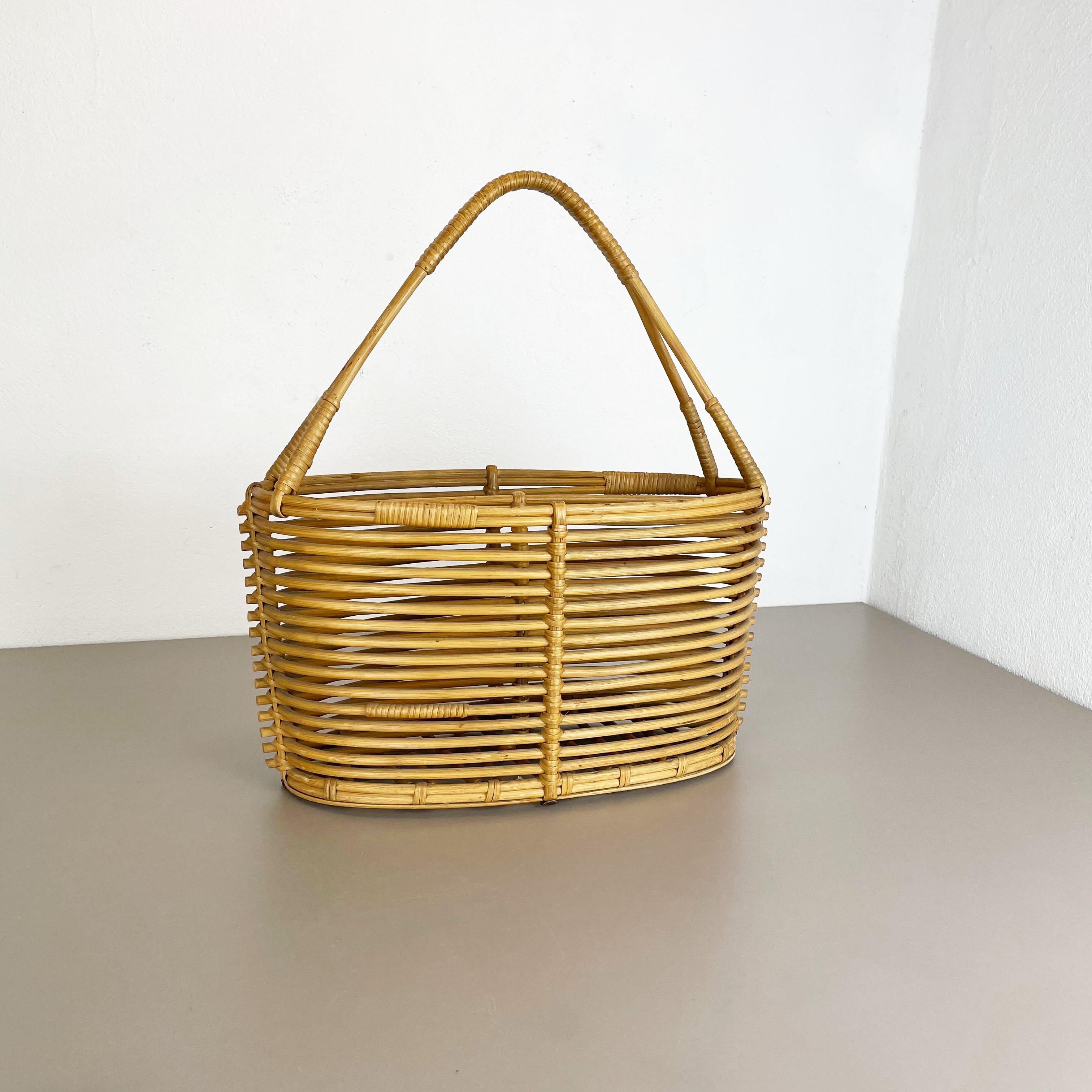 Article: magazine holder stand element

Origin: France

Age: 1970s

This original vintage Bauhaus style magazine holder stand was produced in the 1970s in France. It is made of natural rattan in a oval formed shape and at the top a handle