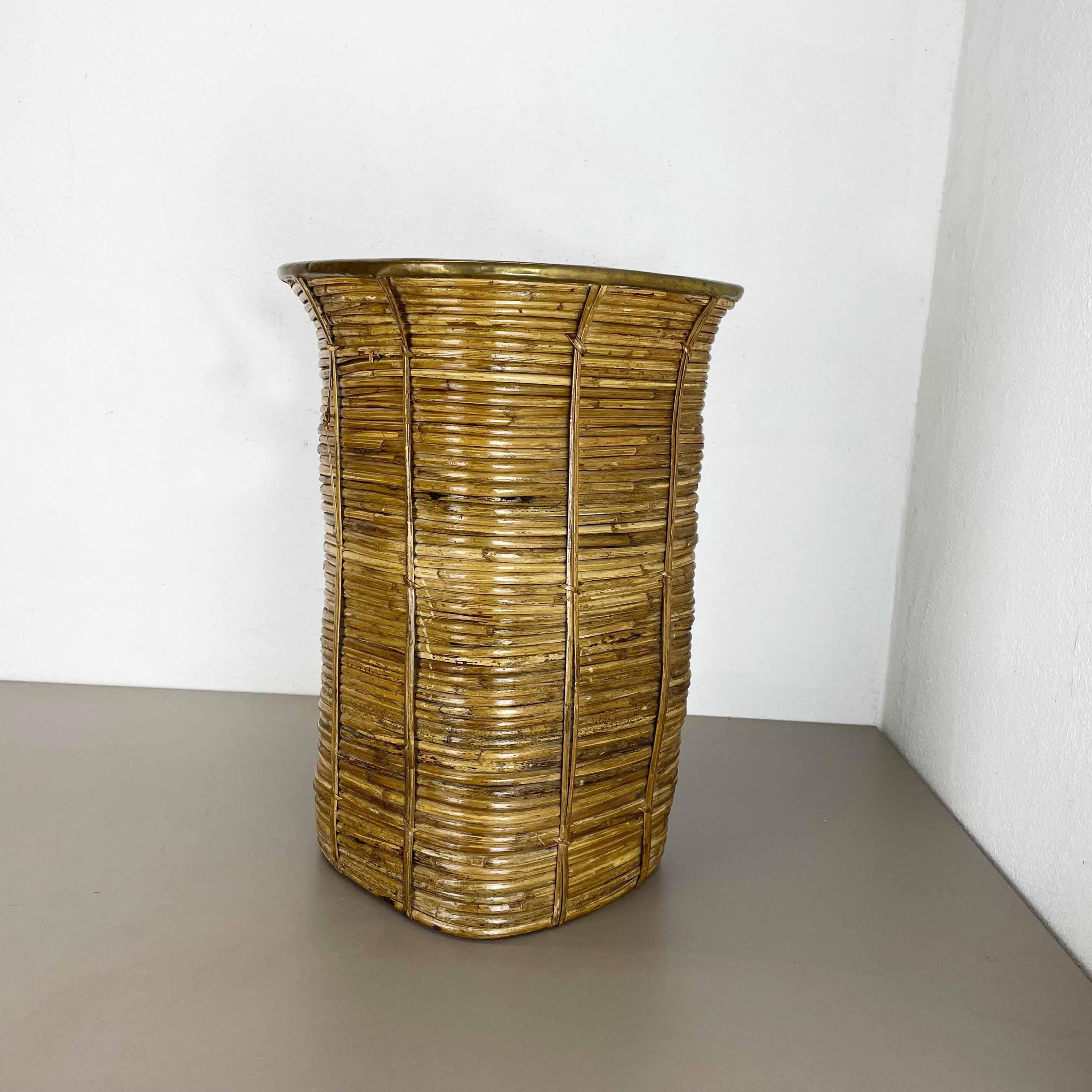 Article: waste bin paper bin umbrella stand

Origin: France

Age: 1960s

This original vintage Bauhaus style waste bin paper bin umbrella stand was produced in the 1960s in France. It is made of natural rattan with a brass applications at the