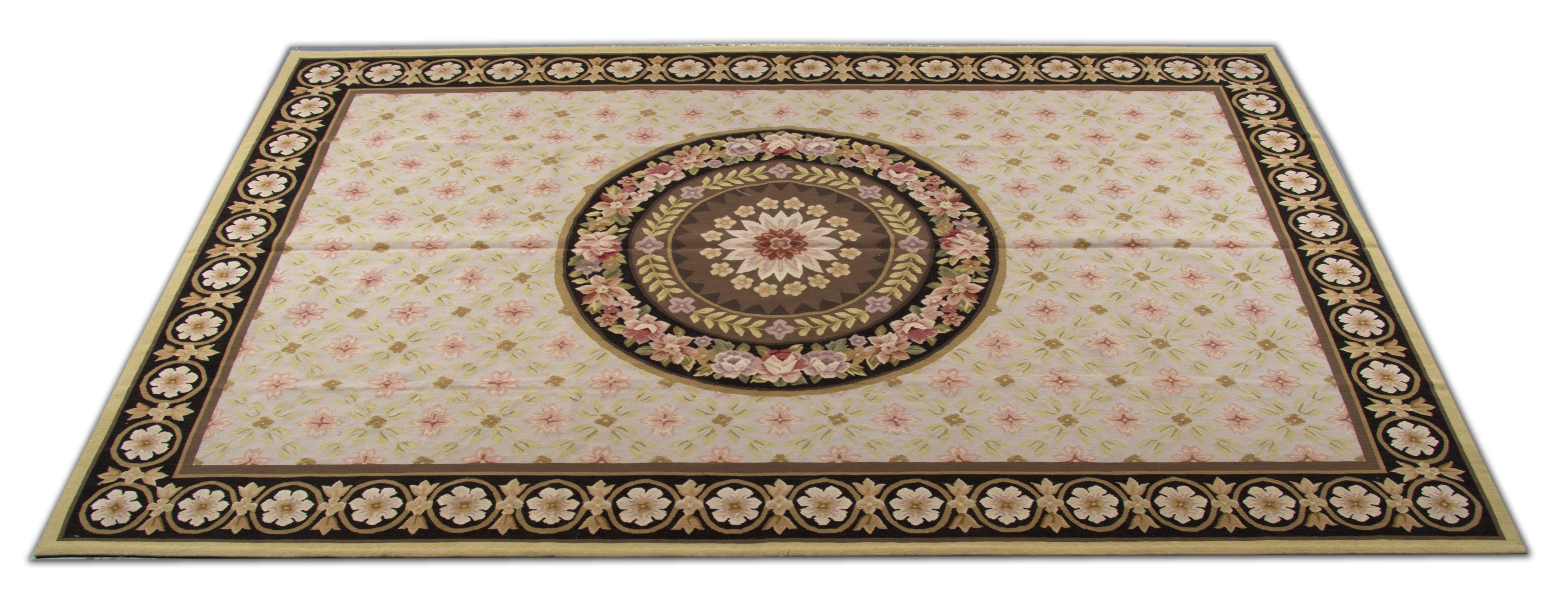 This elegantly handwoven needlepoint Aubusson features a truly unique design with a circular central medallion decorated with beautiful floral design and an all-over repeat pattern surround design. The medallion and border are woven in the same