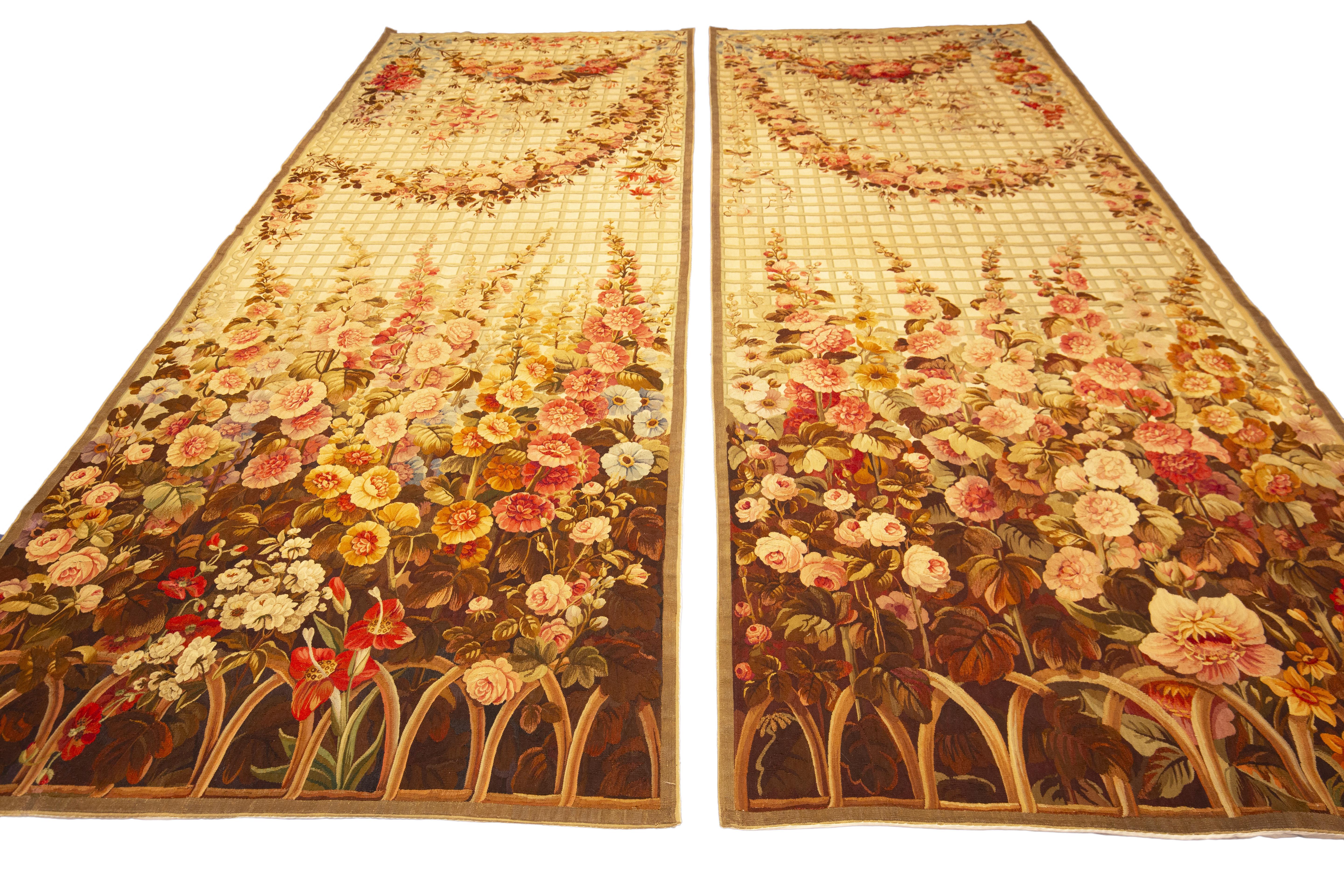 Questa coppia di antichi arazzi di Aubusson  mostra una squisita maestria e un'eleganza senza tempo. Con un'incredibile  Con un disegno floreale e un campo beige ornato da delicati ornamenti floreali, questi arazzi incarnano la raffinata bellezza