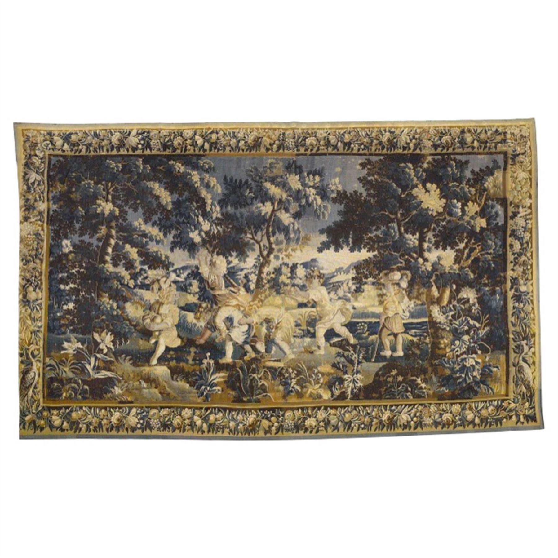 An impressive and decorative Aubusson Verdure tapestry circa 1730, with an extremely fine border decorated with flowers and leaves. Depicting children at play in an idealised woodland landscape. The lower border, early restoration and renewal.