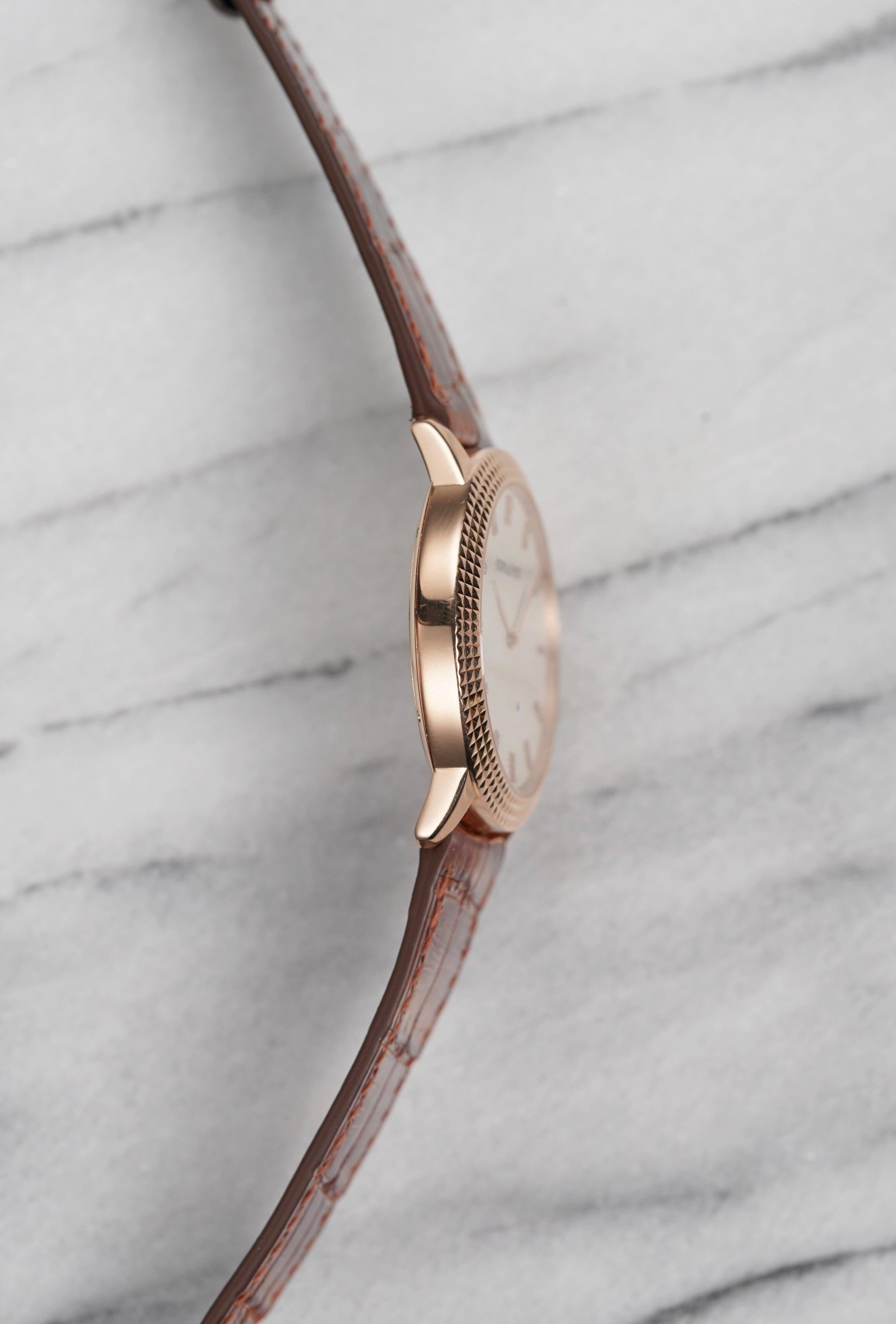 Aquí tienes un Audemars Piguet Jules de cuerda manual en oro rosa de 18 quilates con una nítida esfera waffle color crema y marcadores de diamante aplicados de 2013. Viene con su documentación original. Referencia 15163OR. Las medidas incluyen una
