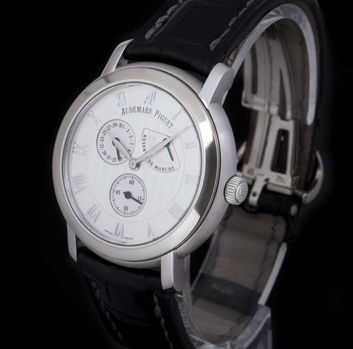 An 18k White Gold Jules Audemars Gents Wristwatch, silver dial with applied roman numerals, power reserve indicator between 1 and 2 0'clock, small seconds at 6 0'clock, date at 10 0'clock, a fixed 18k white gold bezel, an original black leather