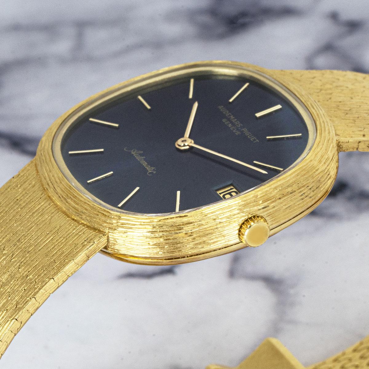 A yellow gold 32mm Dress Watch by Audemars Piguet. Featuring a blue dial with applied hour markers and a textured yellow gold bezel.

Fitted with a sapphire glass, a self-winding automatic movement and a yellow gold integrated bracelet equipped with
