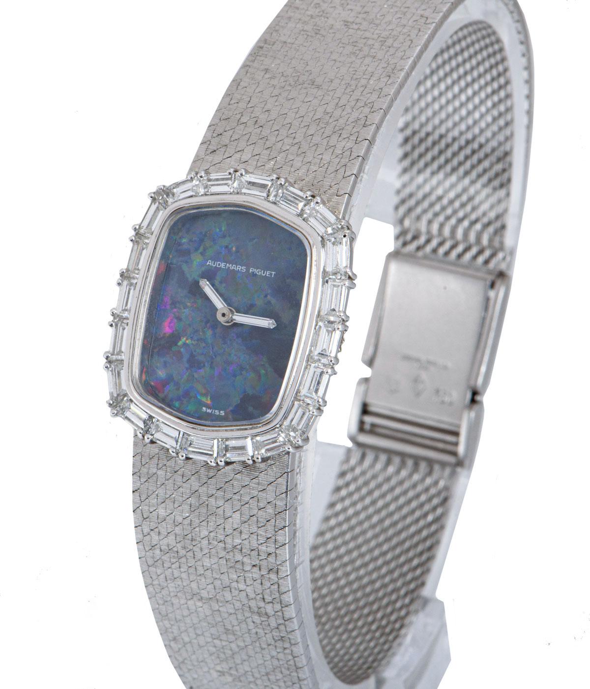 A rare 21mm women's cocktail dress wristwatch, by Audemars Piguet, crafted from 18k white gold and powered by a manual wind movement. 

The exquisite blue opal dial indicates time with baguette cut diamond set hands. Complementing this, is a fixed