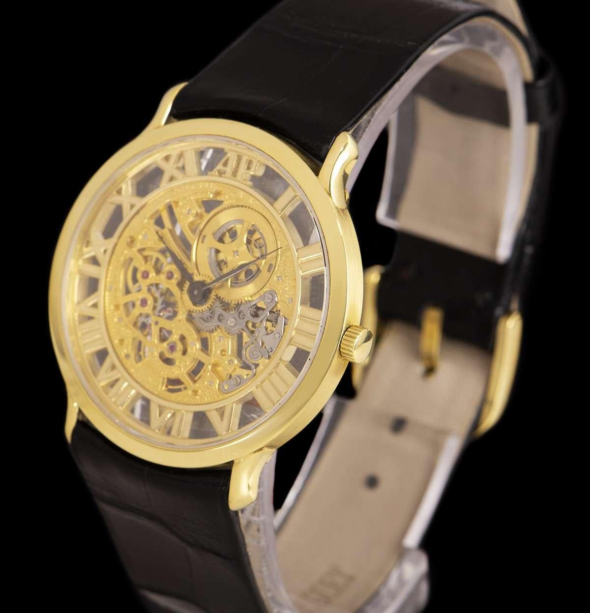 An 18k Yellow Gold Gents Dress Wristwatch, skeleton dial with roman numerals cut out on the outer edge of the dial, a fixed 18k yellow gold bezel, an original black leather strap with an original 18k yellow gold pin buckle, mineral glass, manual