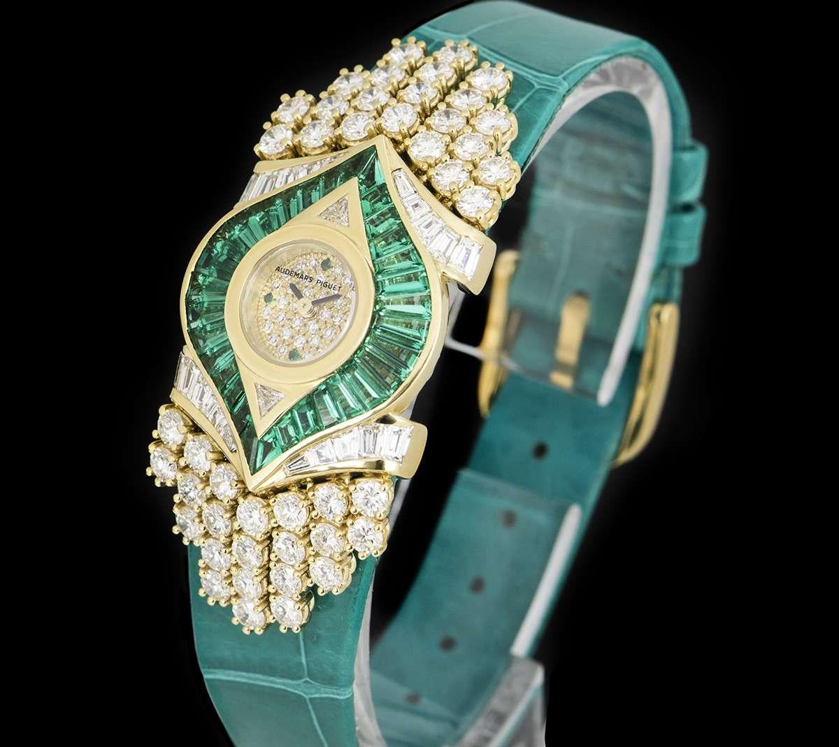 An Unworn Rare 18k Yellow Gold Diamond & Emerald Set NOS Ladies Dress Wristwatch, pave diamond dial with 4 emerald hour markers, a fixed 18k yellow gold bezel set with 2 trillion cut diamonds (~0.1ct), an 18k yellow gold case set with approximately
