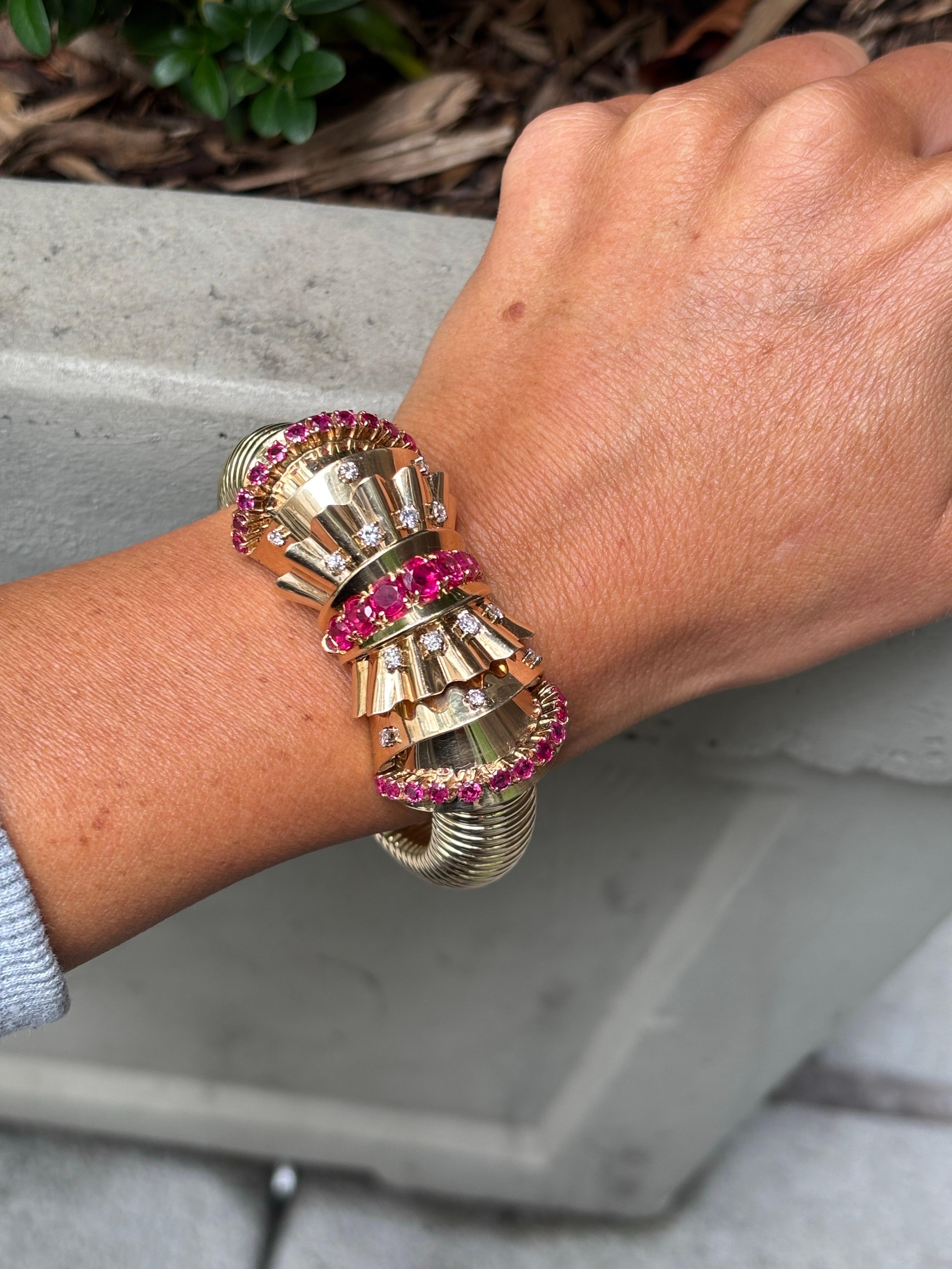Audemars Piguet Rubin & Diamant Verstecktes Uhrenarmband

Eine Armbanduhr mit einem flexiblen Tubogasband. In der Mitte befinden sich Fächermotive mit Rubinen und Diamanten im Rundschliff, die sich zu einem versteckten quadratischen Zifferblatt