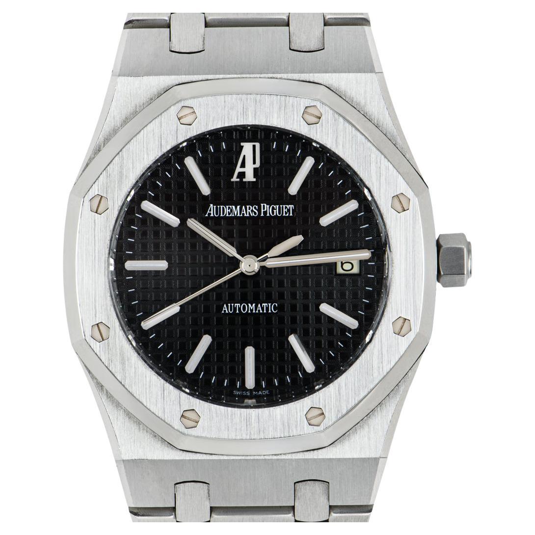 A 39mm stainless steel Royal Oak by Audemars Piguet. Featuring a black dial with a grande tapisserie pattern and a date display at 3 o'clock. The bezel features the iconic 8 screw design which is synonymous with Audemars Piguet.

The bracelet comes