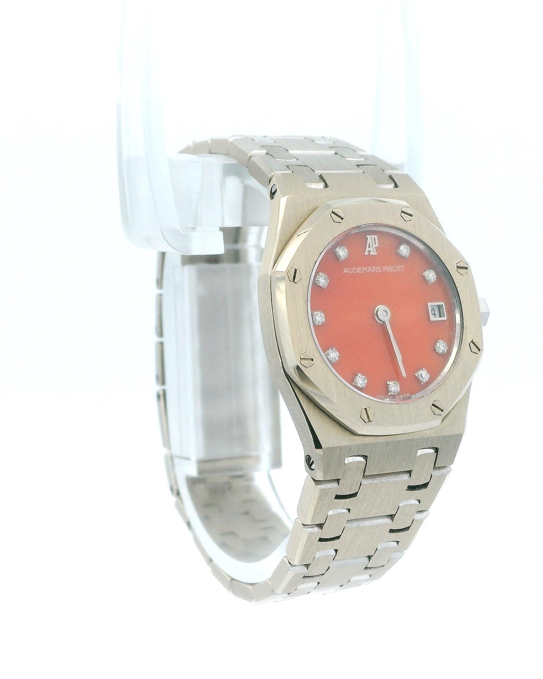 Orologio da donna Audemars Piguet Royal Oak. Questo squisito orologio presenta una cassa da 25 mm in oro bianco 18 carati e una lunetta a forma di ottagono anch'essa realizzata in oro bianco 18 carati. Ha uno splendido quadrante corallo con lancette