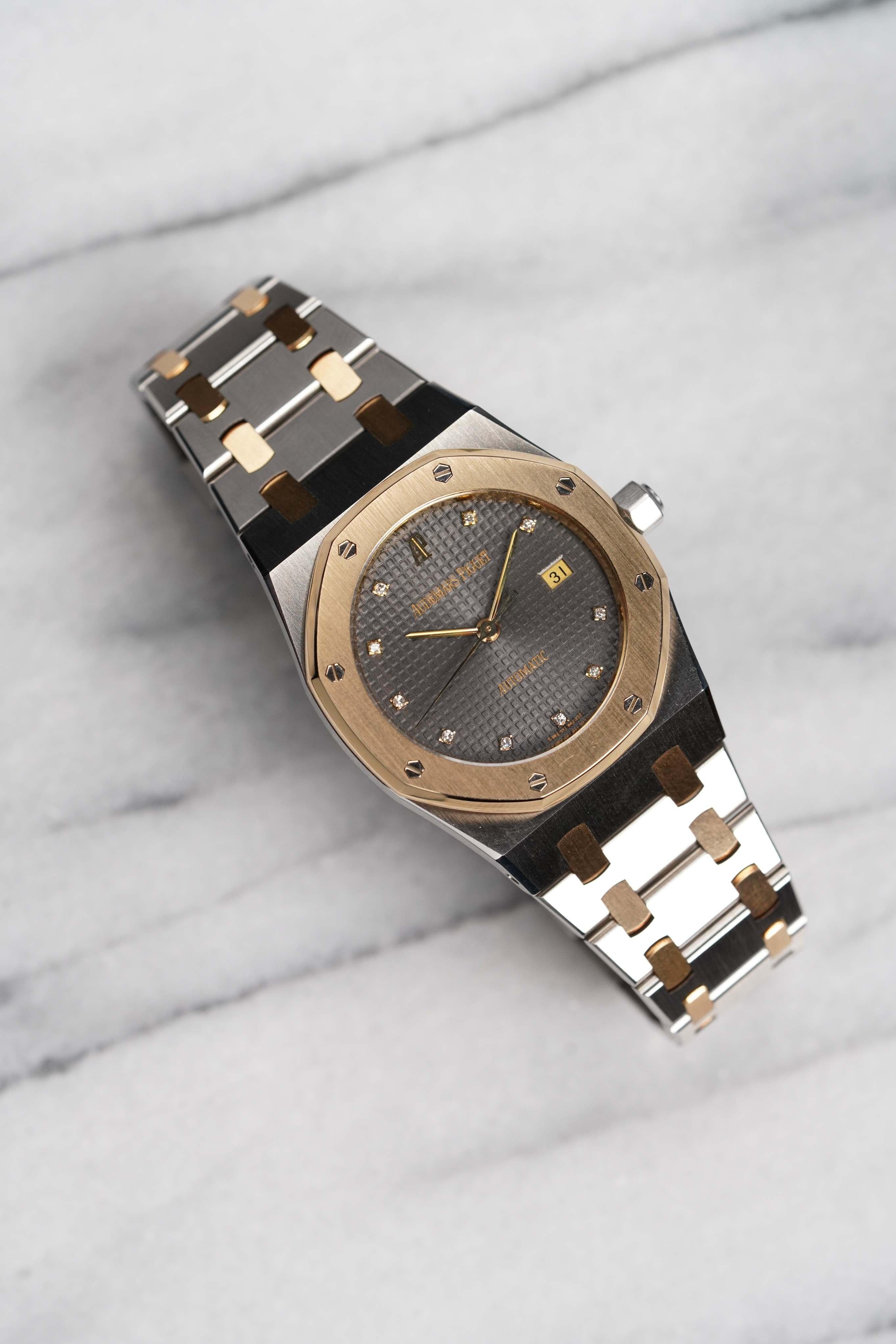 Aquí tienes un Audemars Piguet Royal Oak automático de oro amarillo de 18 quilates y acero inoxidable con una rara esfera gris de diamantes tapisserie, de 33 mm de los años 90. La mayoría de estos automáticos de 33 mm no están en su mejor estado o