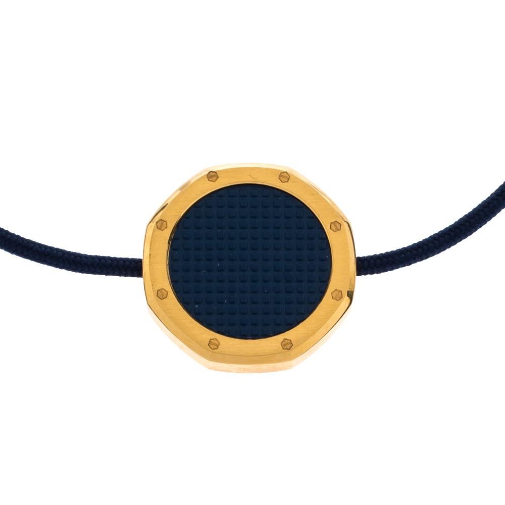 Cette pièce minimaliste d'Audemars Piguet est un accessoire de tous les jours que vous pouvez arborer avec votre garde-robe polyvalente. L'emblématique motif Royal Oak est utilisé comme charme en métal doré. Le bracelet est complété par un cordon