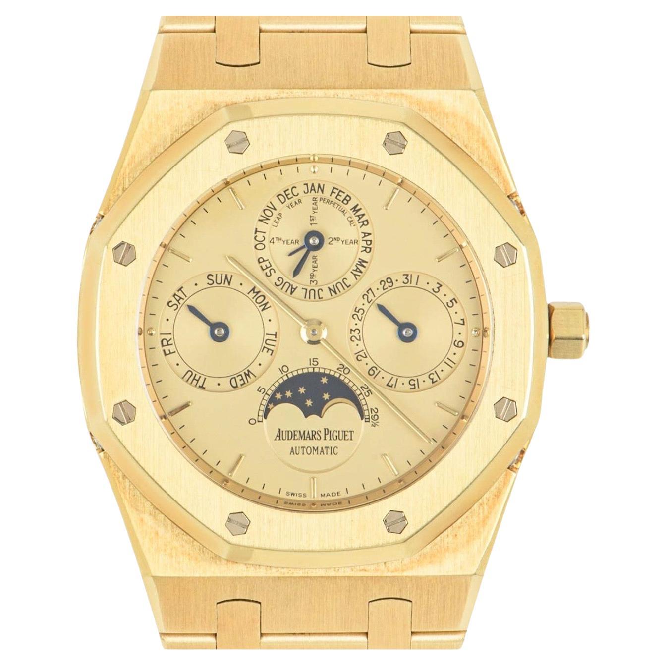 A Perpetual Calendar in yellow gold from Audemars Piguet's Royal Oak collection. Featuring a champagne dial and a bezel featuring the iconic 8 Audemars Piguet screws. The dial itself has displays of the moon phases, the day, the date and the month
