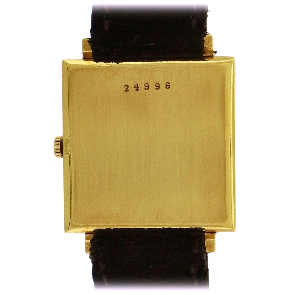 18K yellow gold Audemars Piguet, Genève, circa 1964, is a rare, elegant, thin, square, 18K yellow gold wristwatch. The 26mm square case is very thin, the ivory dial with painted black radial hash mark hours, gold baton hands, caliber 2003