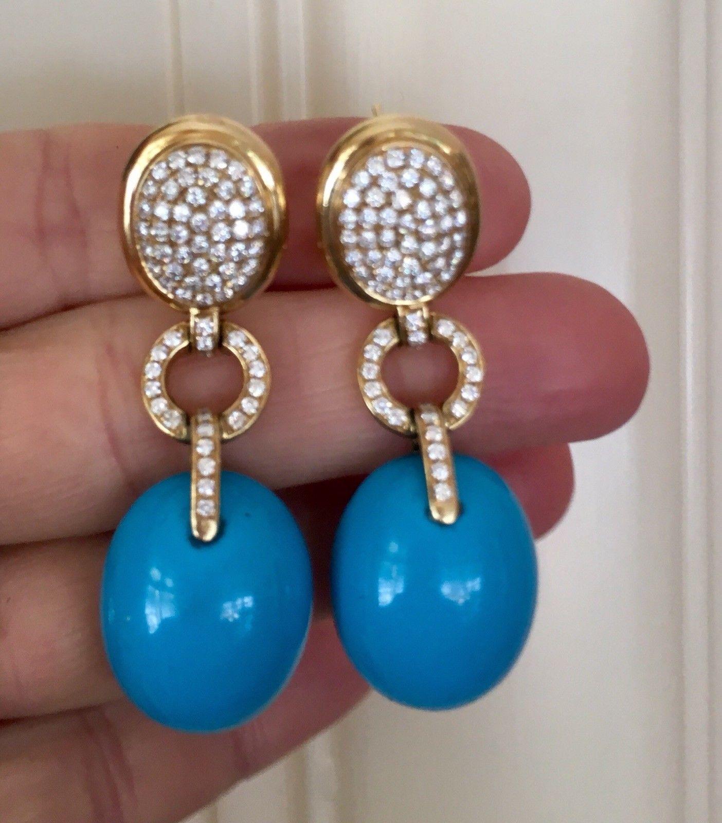These stunning designer earrings are set in 18K yellow gold  featuring beautiful rich blue oval turquoise cabochons and 1.98 carats of round brilliant diamonds with omega back closures.

The total measurement of the earrings is 2