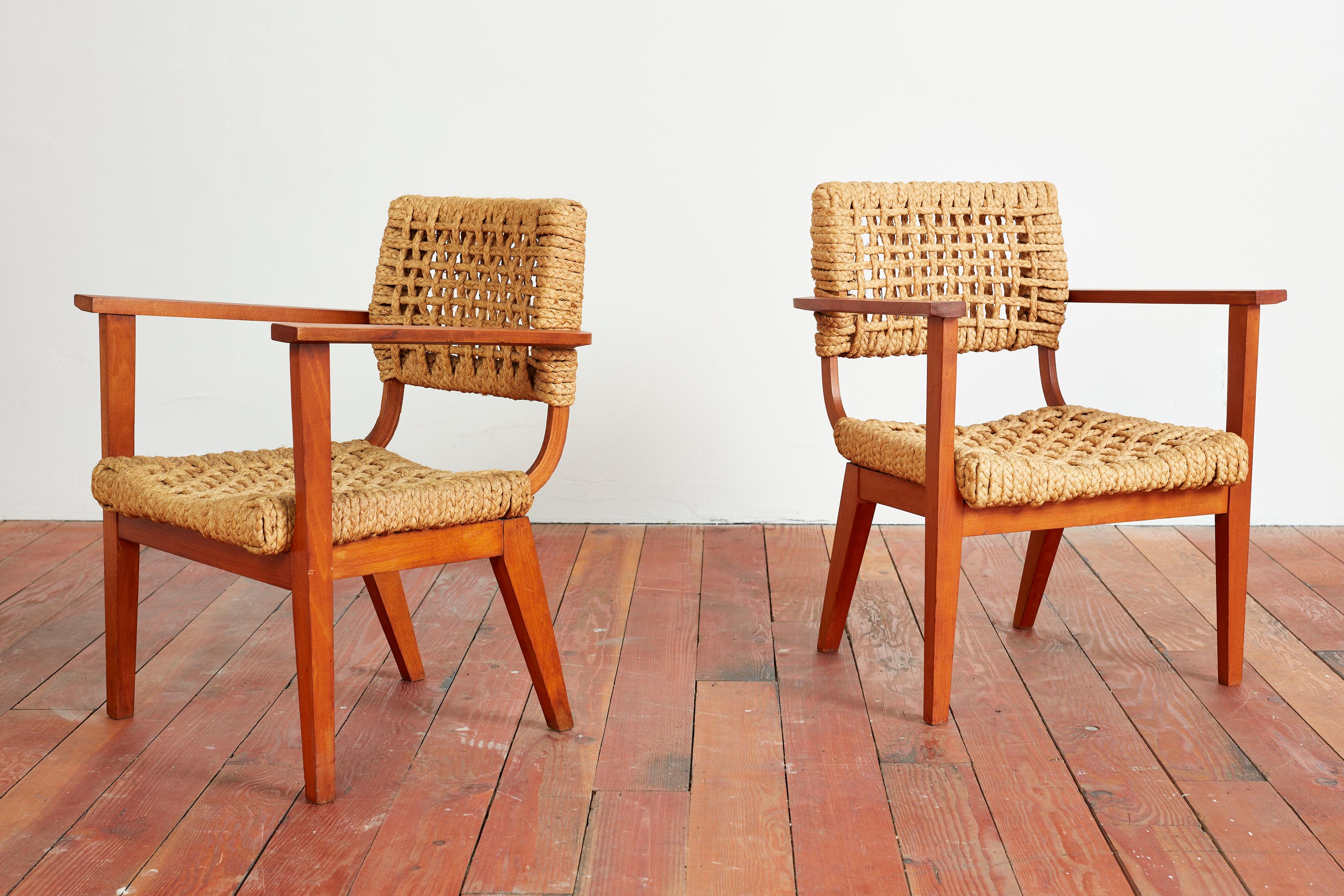 Fantastique paire de fauteuils Audoux Minet avec des cadres en chêne et des sièges en corde.
France, vers les années 1950.