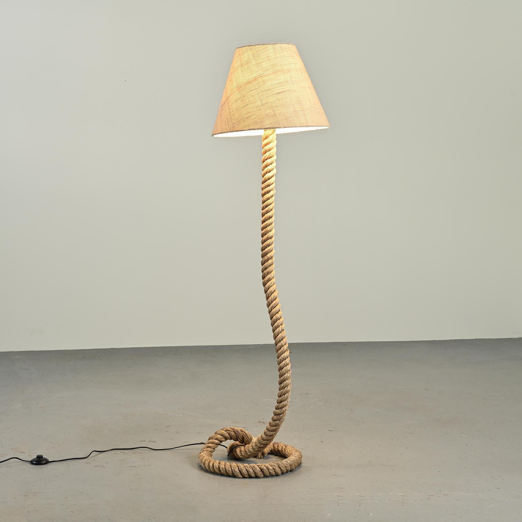 Floor lamp, in the style of Audoux Minet : it is made out a rope feet and a cream color shade.