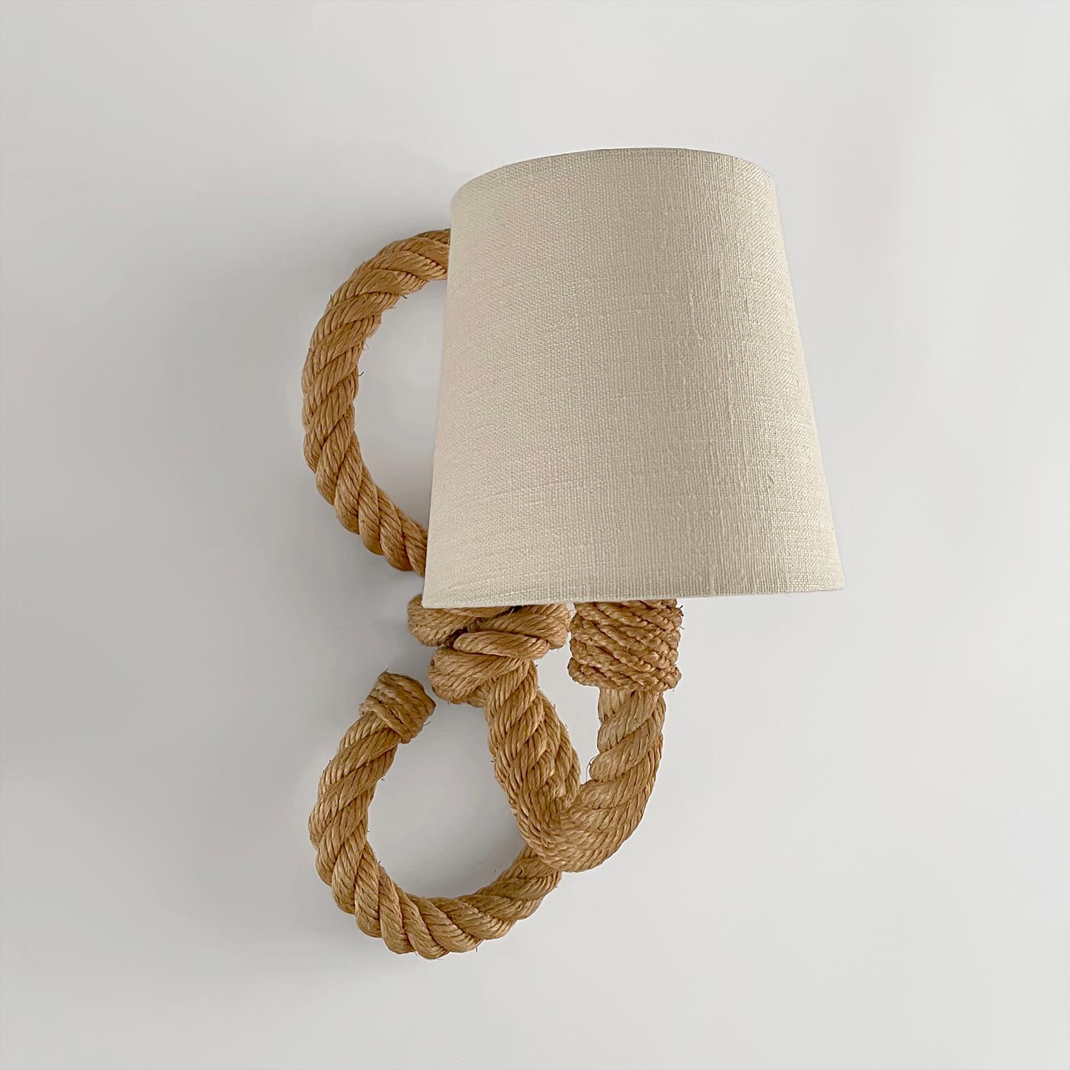 Adrien Audoux & Frida Minet rope sconce
France, circa 1950s
Thick sculpted rope loop frame supports an extending arm of light
Natural color variations throughout
New linen shade 
Newly rewired 
Single socket candelabra base 
Patina from age and use