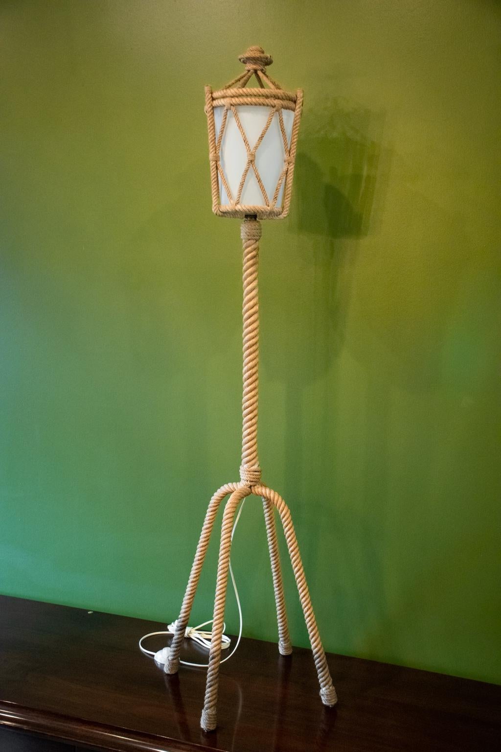 Iconic piece by famed mid-century design duo Adrien Audoux and Frida Minet. Floor lamp has four legs and lantern shaped top, wrapped in rope. Includes original rhodoid (synthetic-like thin plastic) liner at lantern. Has been newly rewired for US use