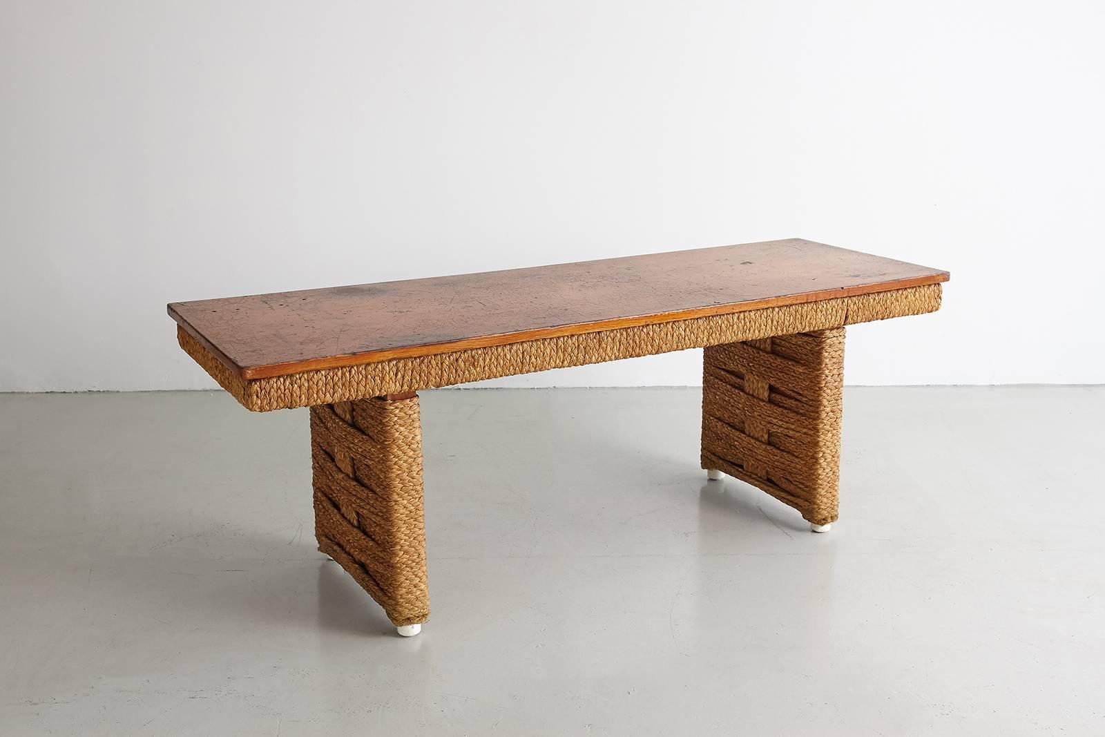 Fantastic French table by Audoux Minet with woven rope detailing and wood top. Wonderful patina and scale. Can be used as a bench or coffee table option.