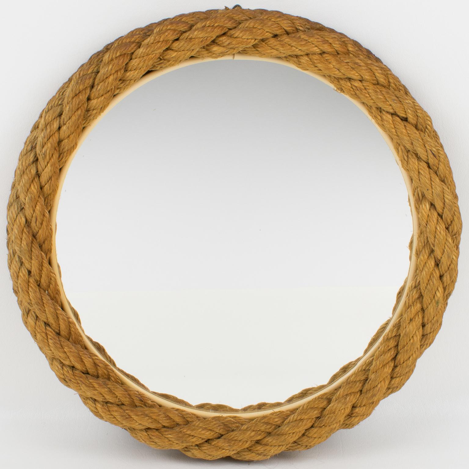 Questo specchio da parete è stato progettato da Audoux Minet a Golfe-Juan, in Costa Azzurra, intorno al 1960. La struttura rotonda è realizzata in abaca intrecciata con un disegno di corda nautica.
Dimensioni: 13,19 di diametro (33,5 cm). L'inserto