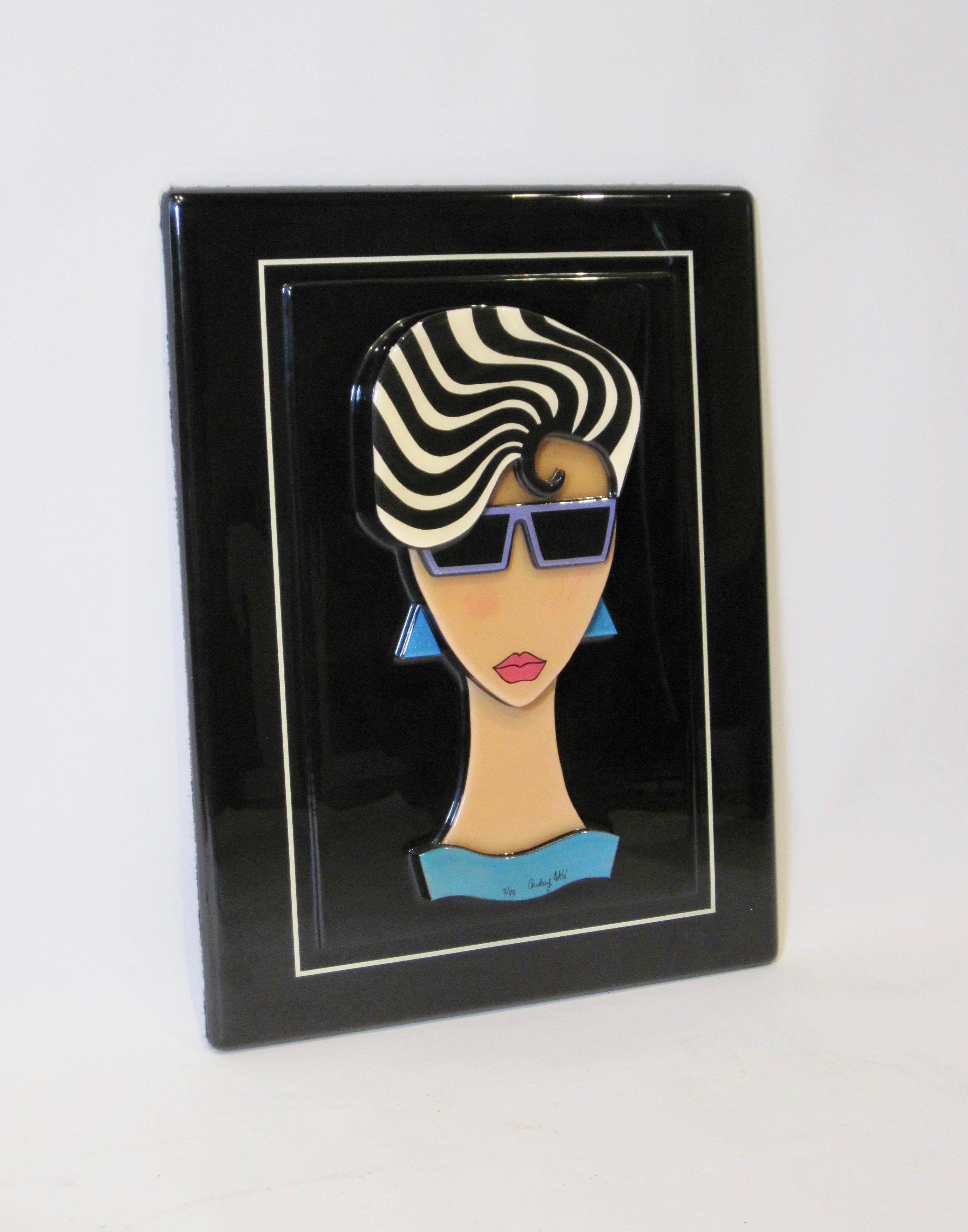 Vividly colored geometric forms against a black background spring forward on this theatrical three dimensional art relief sculpture. As a style statement, she's post-modern polished cool in the 'designer decade'- her black & blonde striped wavy