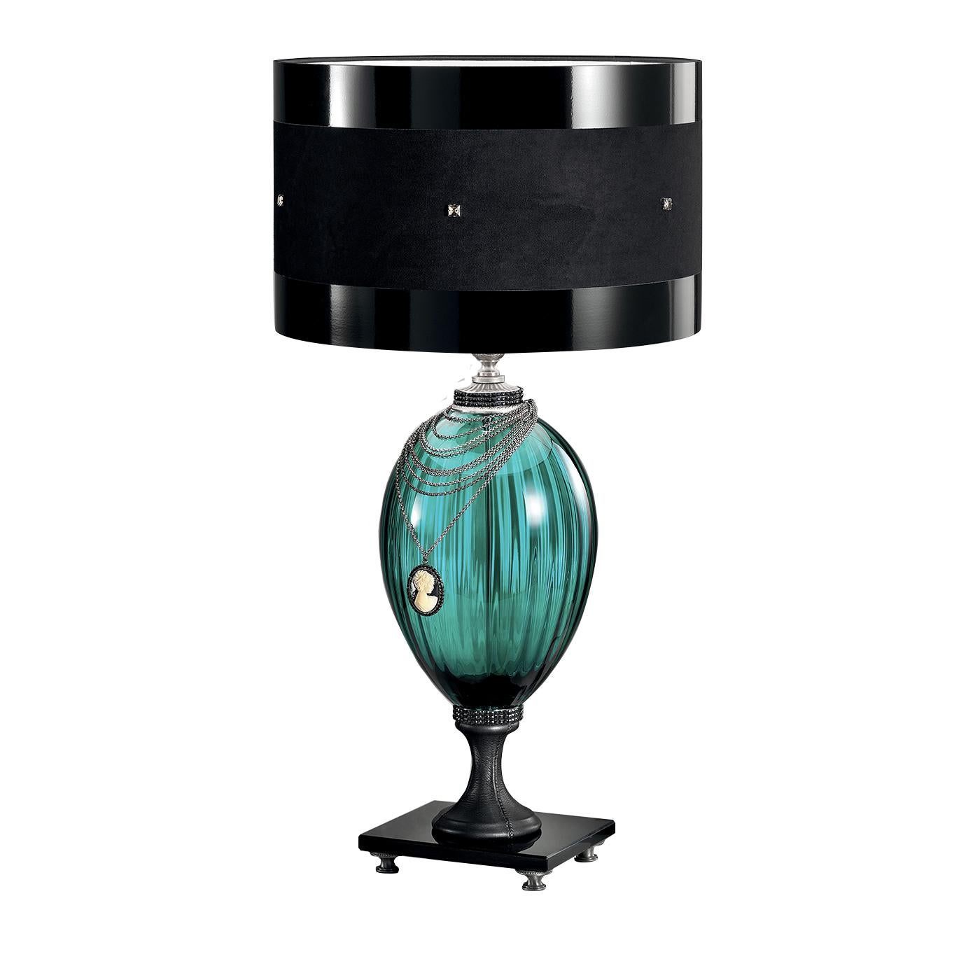 True protagonist of this magnificent lamp is the drum shade made of shiny, black chintz fabric with a bold alcantara central band and square antiqued silver details. Its refined black marble base with black rhinestones and black leather flared foot