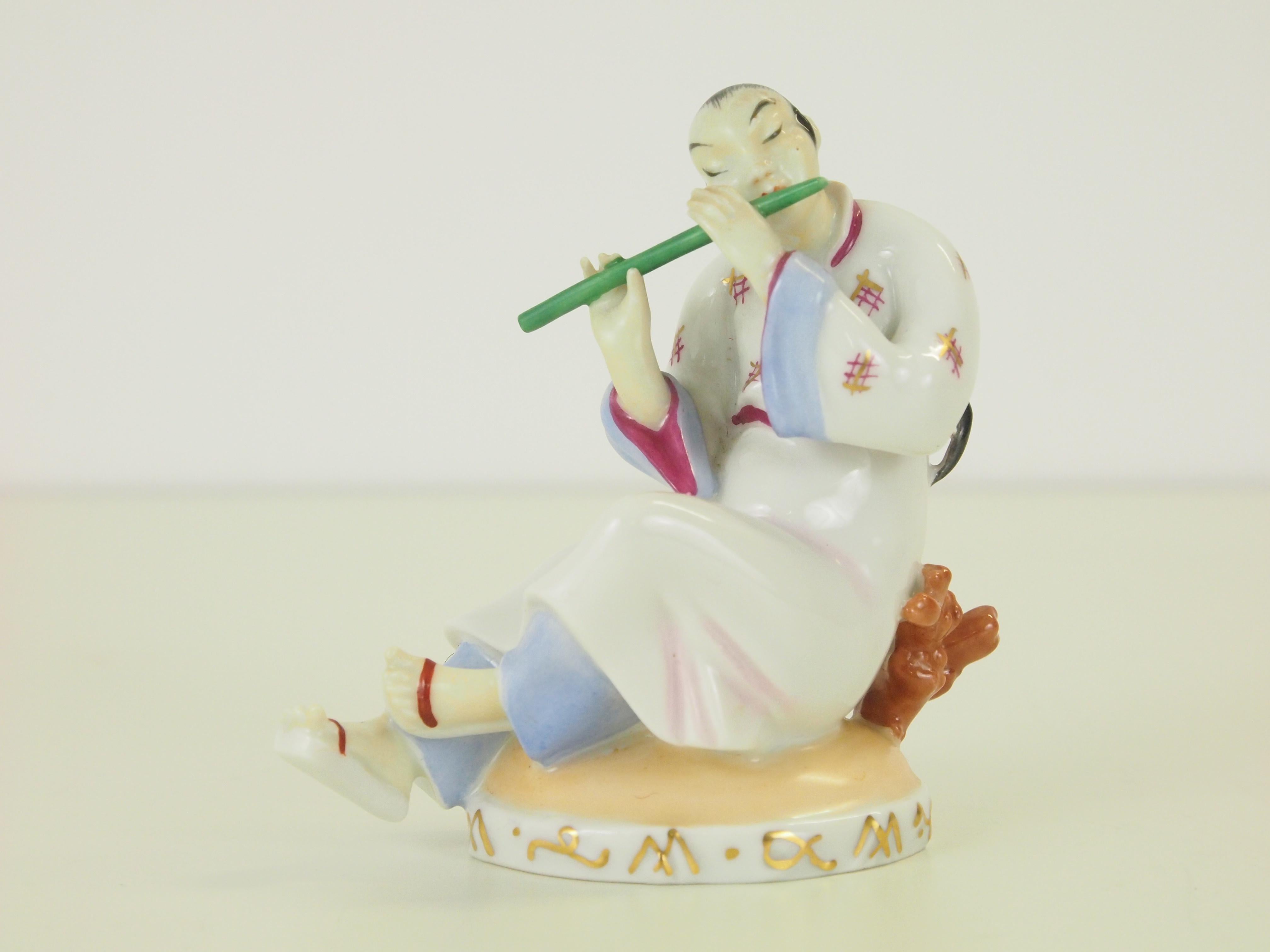 Delicate fine porcelain figurine depicting a Chinese man plating the flute

This figurine was (like the other figurine depicting a Chinese woman) designed in 1926 by Mathilde Szendrö-Jaksch for Augarten Wien (Vienna). It is very well handcrafted