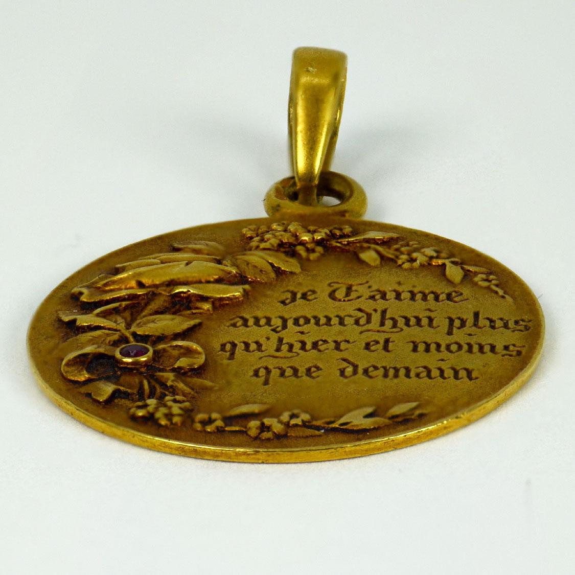 A French 18 karat (18K) yellow gold, diamond and ruby love charm pendant engraved 