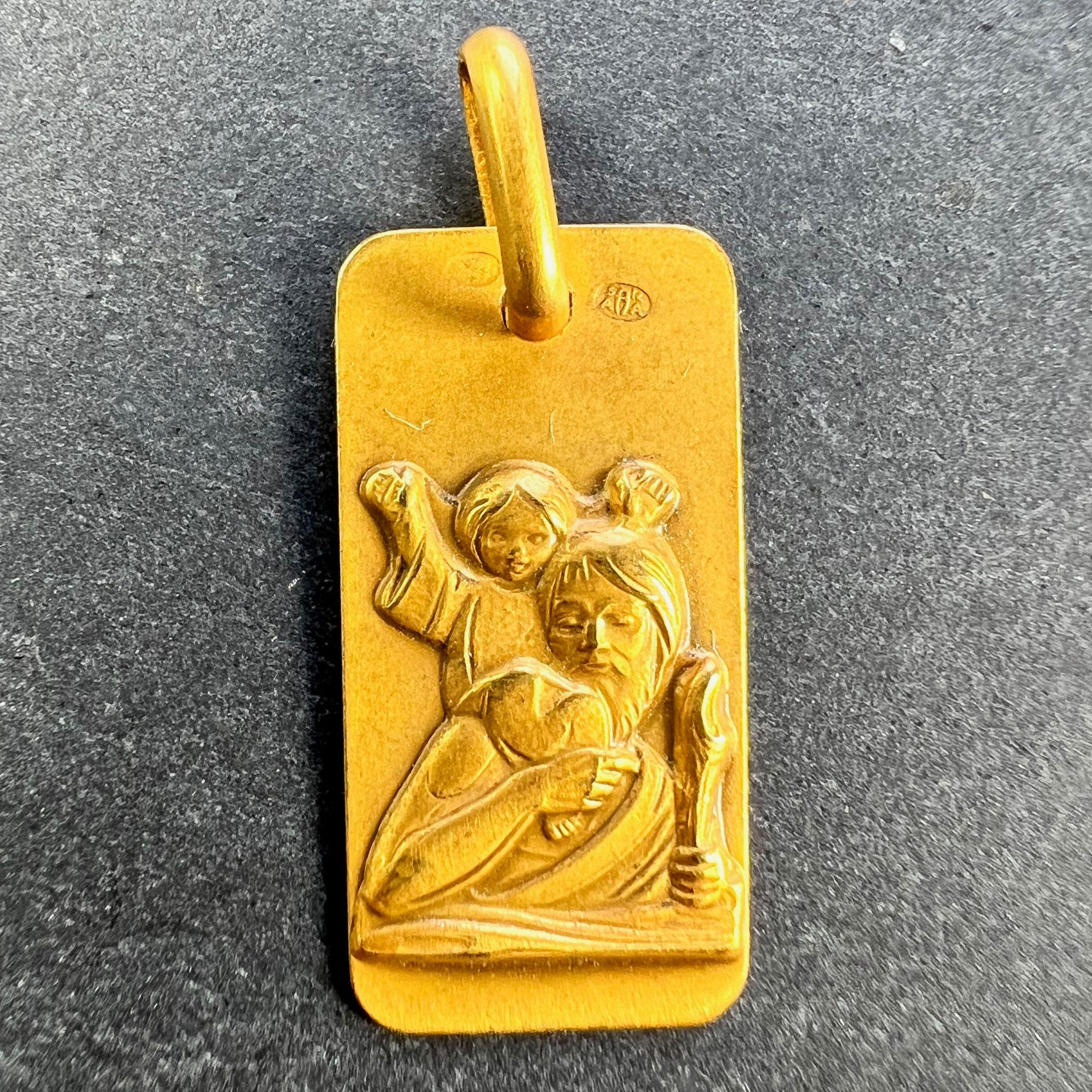A vintage French 18 karat (18K) yellow gold rectangular charm pendant or medal depicting St Christopher carrying the infant Christ across the river. Stamped for French manufacture and 18 karat gold along with Augis' makers mark.

Dimensions: 1.8 x