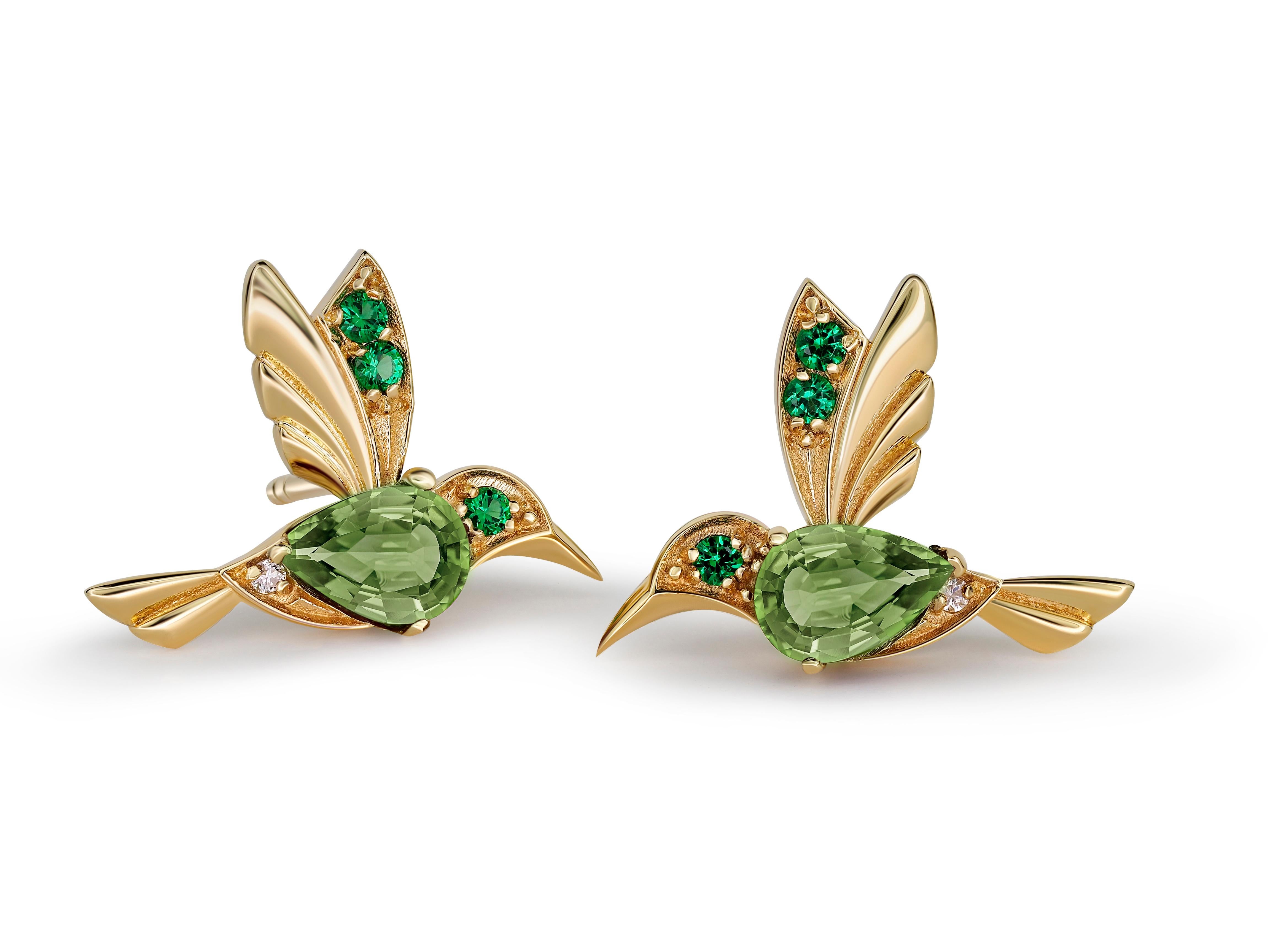 14k Gold Hummingbird earrings studs with peridots. 
Bird Stud Earrings with gems. Peridot august earrings. Delicate Animal Earrings.

Metal: 14 karat gold.
Weight: 1.95 g.
Size: 11.73 x 15.85 mm.

Central stones: Genuine peridots
Cut:  pear
Weight: