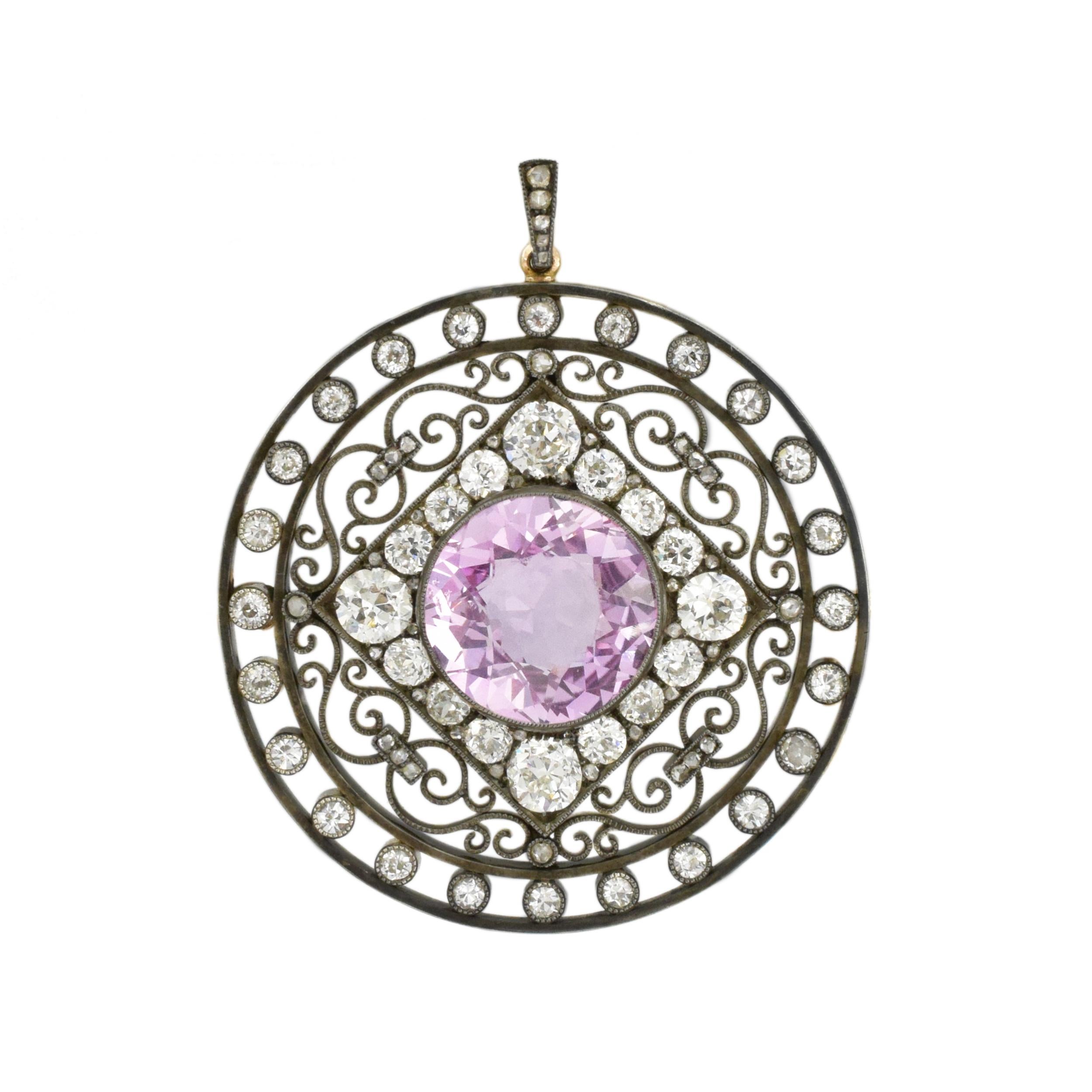 August Holmström for Fabergé; Antique Silver, Gold, Pink Sapphire and Diamond Brooch. This circular wire pendant features approximately 7.30carats round pink sapphire
surrounded by a square frame encrusted with 16 cushion-shaped and old European-cut