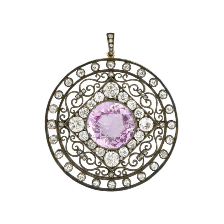 August Holmström for Fabergé; Antique Silver, Gold, Pink Sapphire and Diamond Brooch. This circular wire pendant features approximately 7.30carats round pink sapphire
surrounded by a square frame encrusted with 16 cushion-shaped and old European-cut