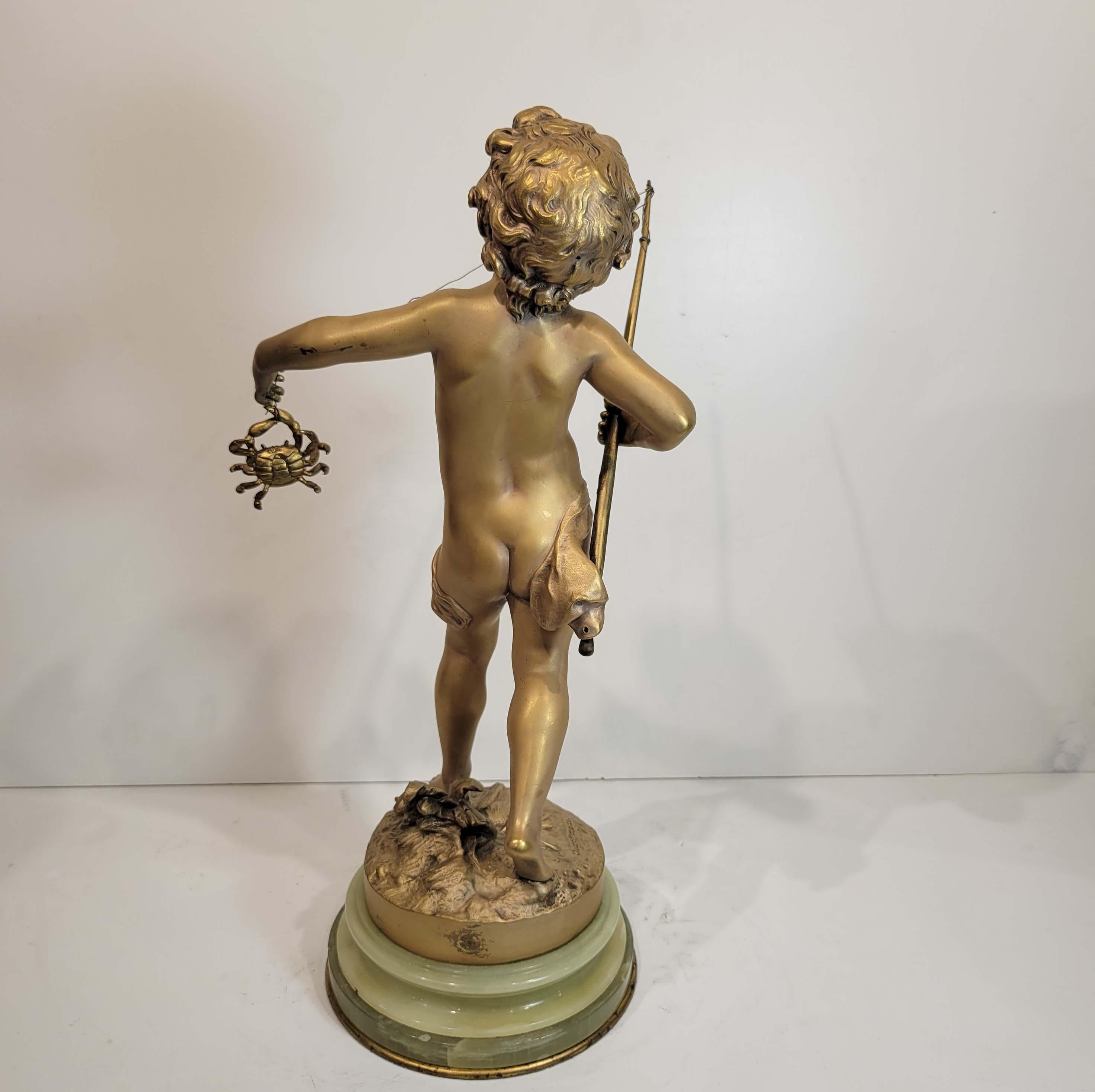 An adorable gilt bronze sculpture of a boy fishing a crab in his surprise. Wonderful details and original matte gilding on an onyx and bronze base. Signed on the base 