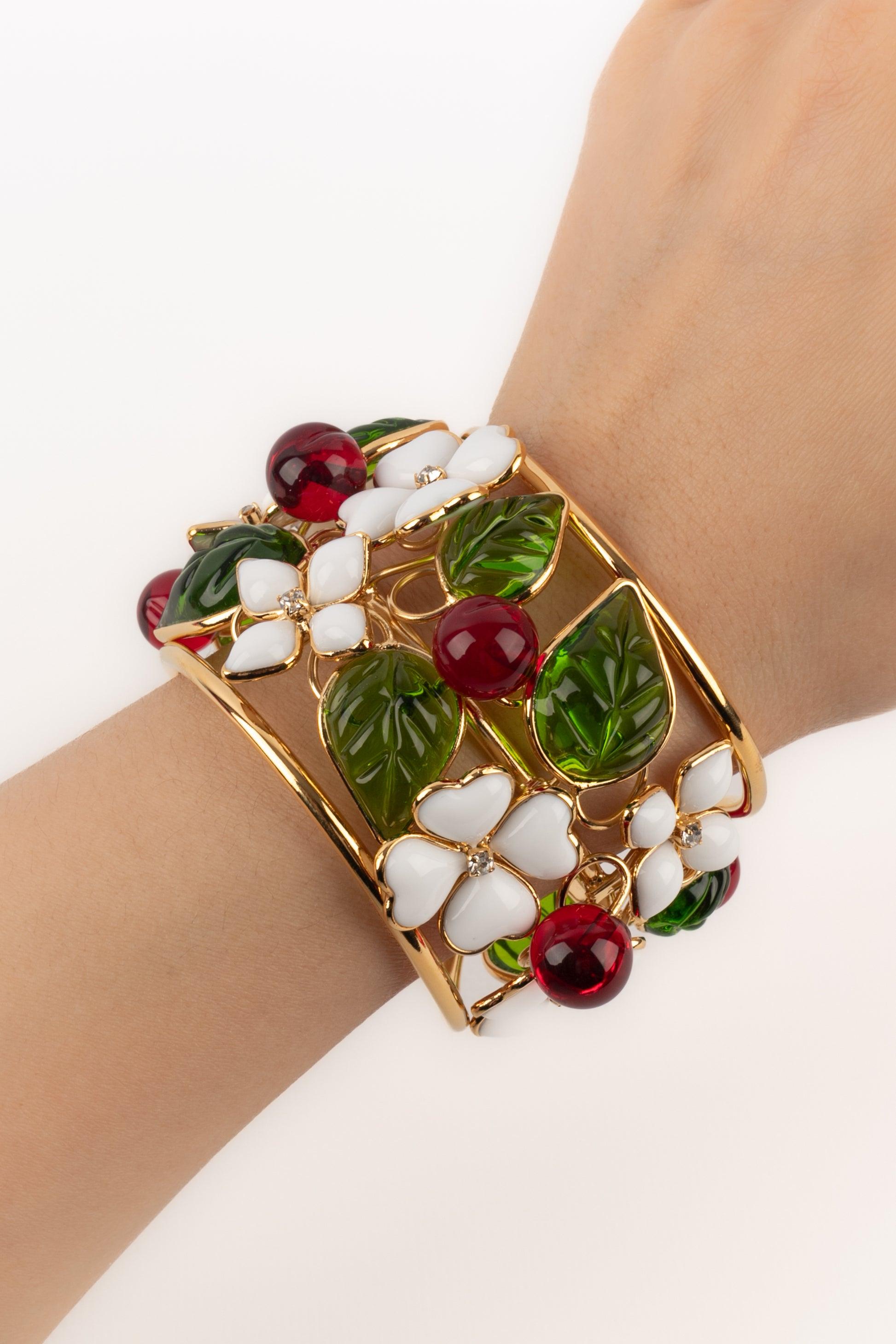 Augustine - (Made in France) Bracelet manchette en métal doré et pâte de verre présentant des petites fleurs blanches et des baies rouges.

Informations complémentaires :
Condit : Très bon état.
Dimensions : Circonférence : 13 cm - Ouverture : 2,5