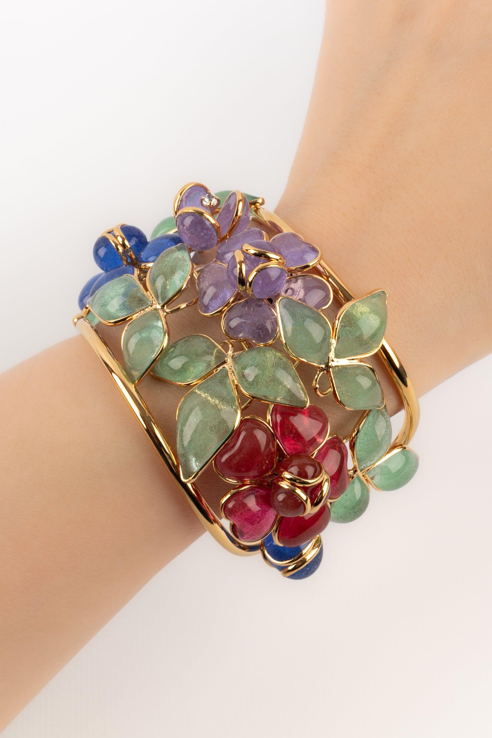 Augustine - (Made in France) Cuff bracelet in gold metal and glass paste flowers in shades of red, blue and purple.

Additional information:
Condition: Very good condition
Dimensions: Circumference: 13.5 cm - Opening: 3 cm - Width: 4.5 cm

Seller