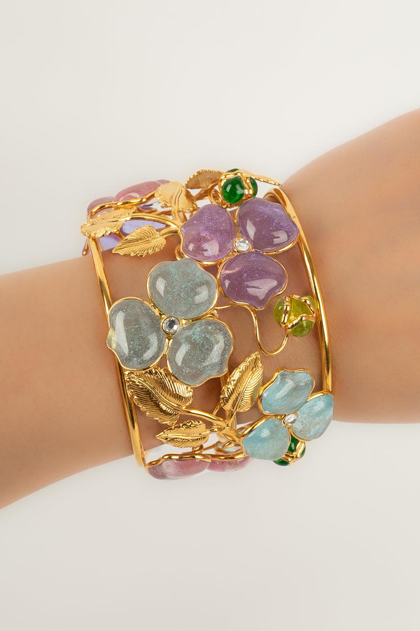 Augustine - (Made in France) Gold-plated metal cuff bracelet with glass paste flowers.

Founder of the AUGUSTINE House, Thierry Gripoix left us on July 7th 2022.
Son of Josette Gripoix, grandson of Suzanne Gripoix, great-grandson of Augustine,