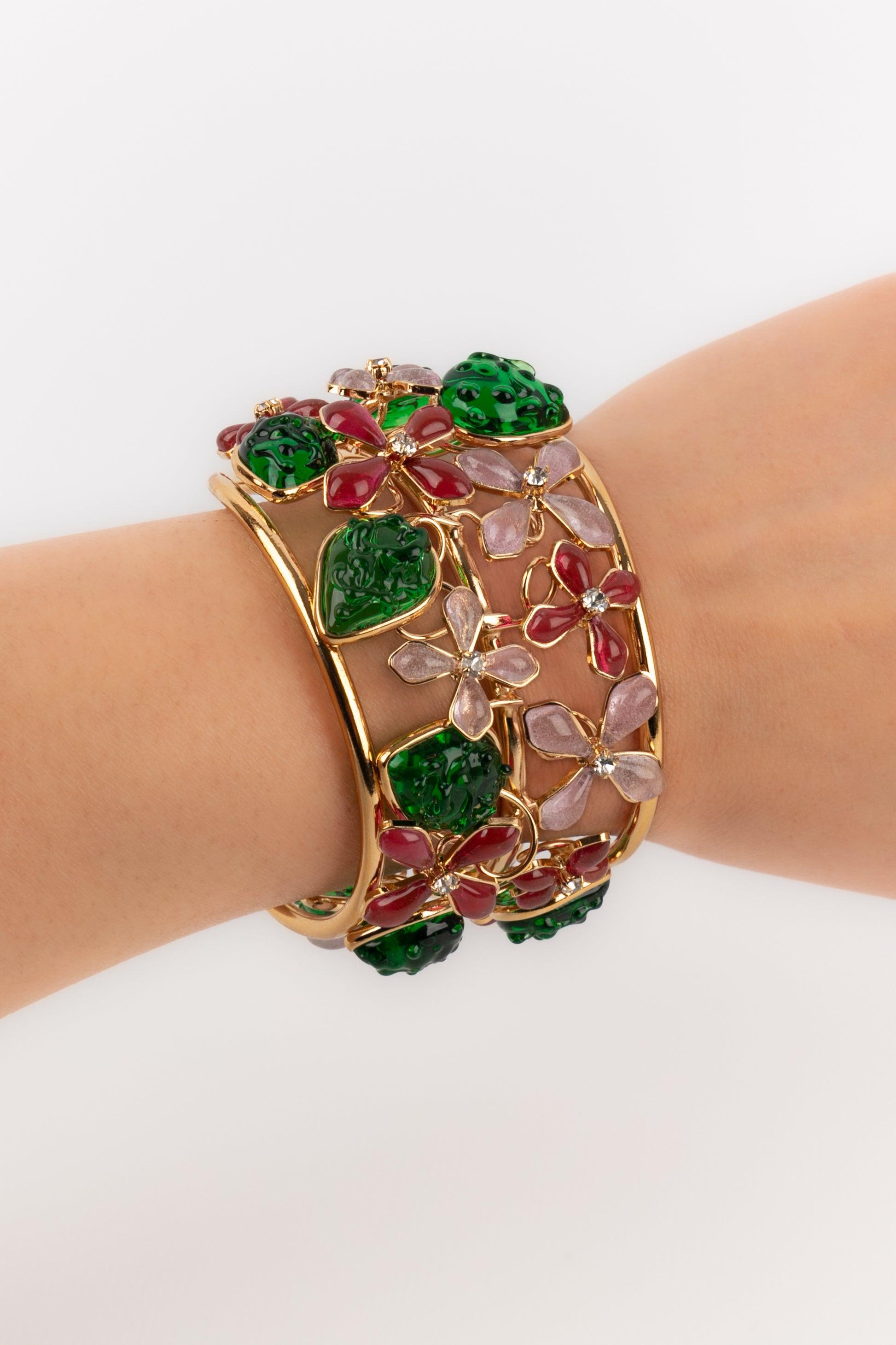 Augustine - (Made in France) Bracciale in metallo dorato con pasta di vetro rosa raffigurante fiori e strass.

Informazioni aggiuntive:
Condizioni: Ottime condizioni
Dimensioni: Circonferenza: 14 cm - Apertura: 2,5 cm - Larghezza: 4 cm

Riferimento
