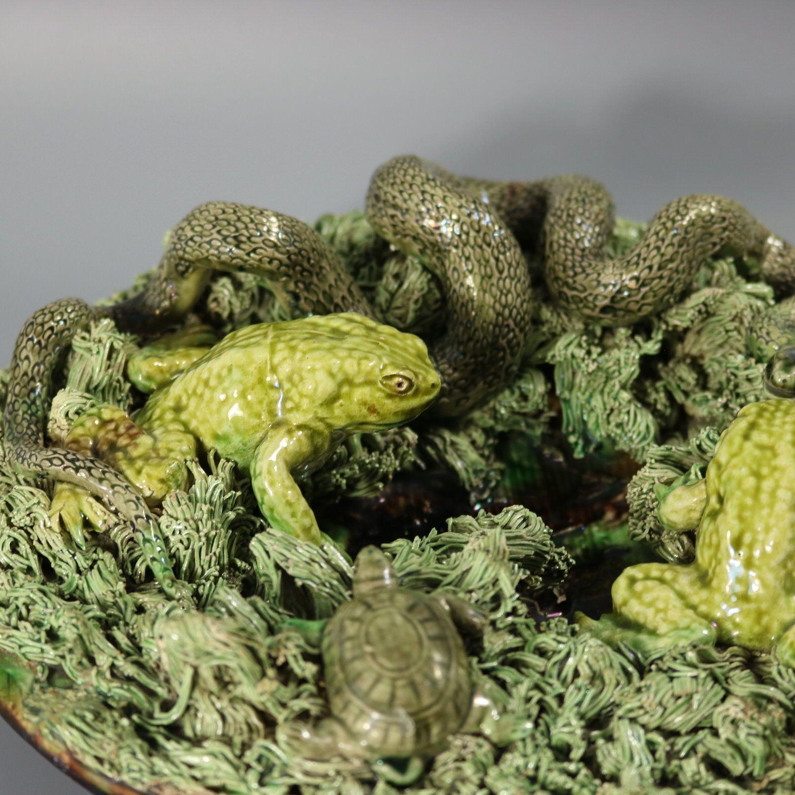 Augusto Baptista de Carvalho portugiesischer Wandteller aus Palissy Majolika mit einer Schlange, zwei Fröschen und einer Schildkröte, die einen zentralen Brunnen umgeben. Färbung: Grün, grau, braun, sind vorherrschend. Das Stück trägt die