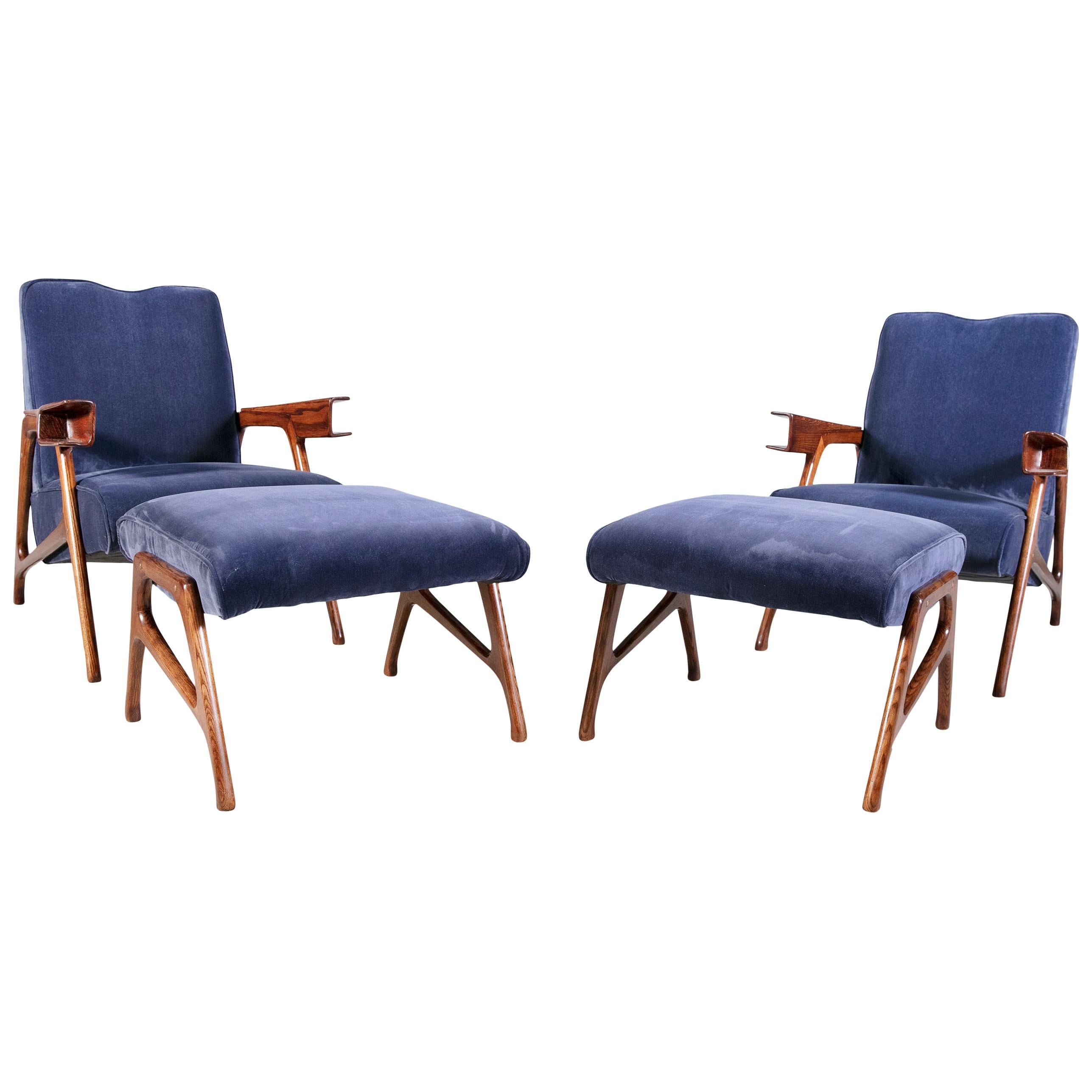 A very rare pair of solid oak Italian mid-20th century armchairs and matching ottomans by Augusto Romano. The chairs and ottomans have been professionally re-covered in a plush, blue, velvet and the wood re-polished.
These armchairs and ottomans