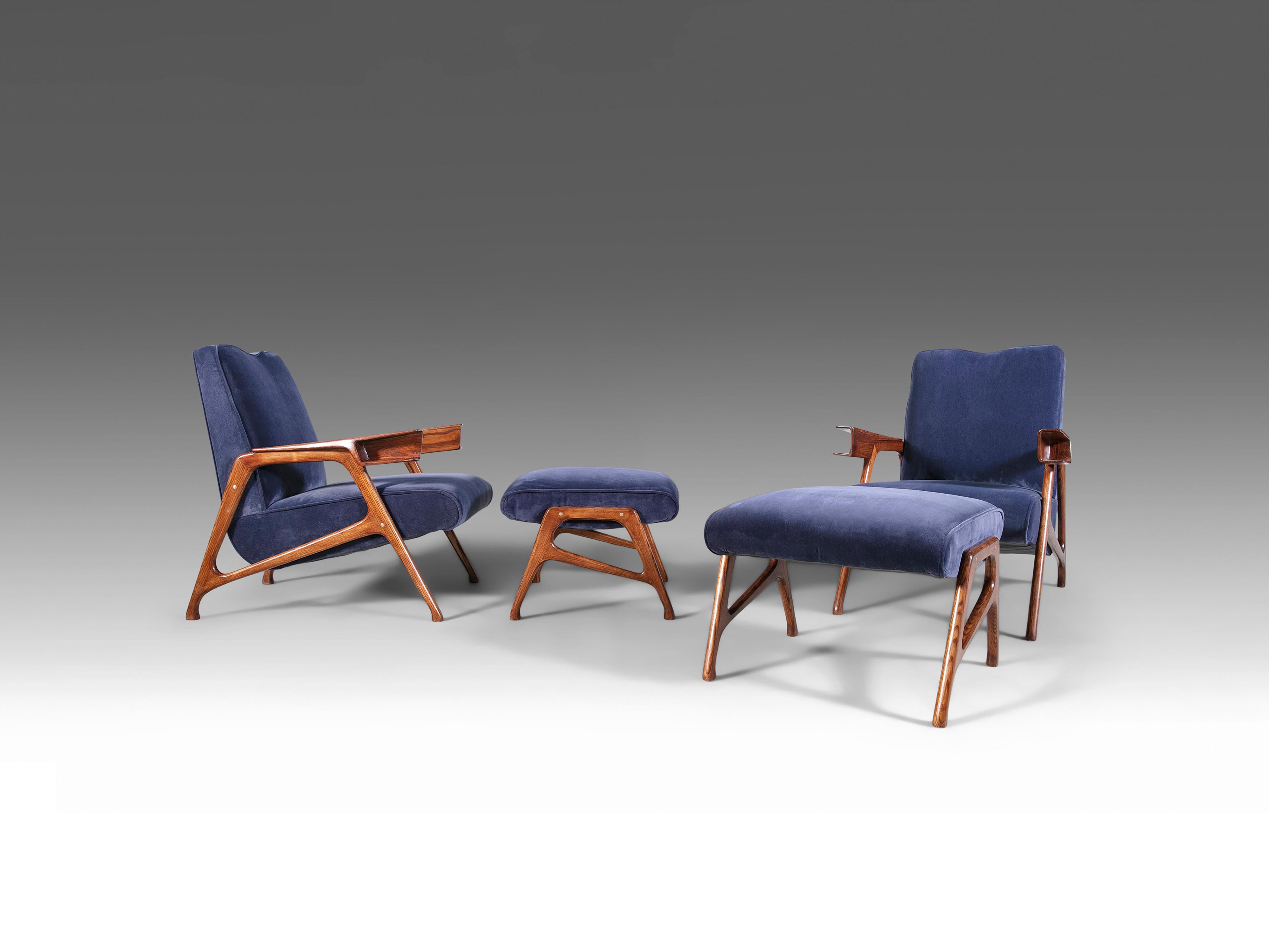 Una squisita coppia di poltrone e pouf, disegnata dal famoso architetto modernista italiano Augusto Romano per Cassina. Fabrice in ricco mogano con eleganti dettagli in ottone, ogni set è rivestito in un lussuoso tessuto di velluto blu. Le poltrone