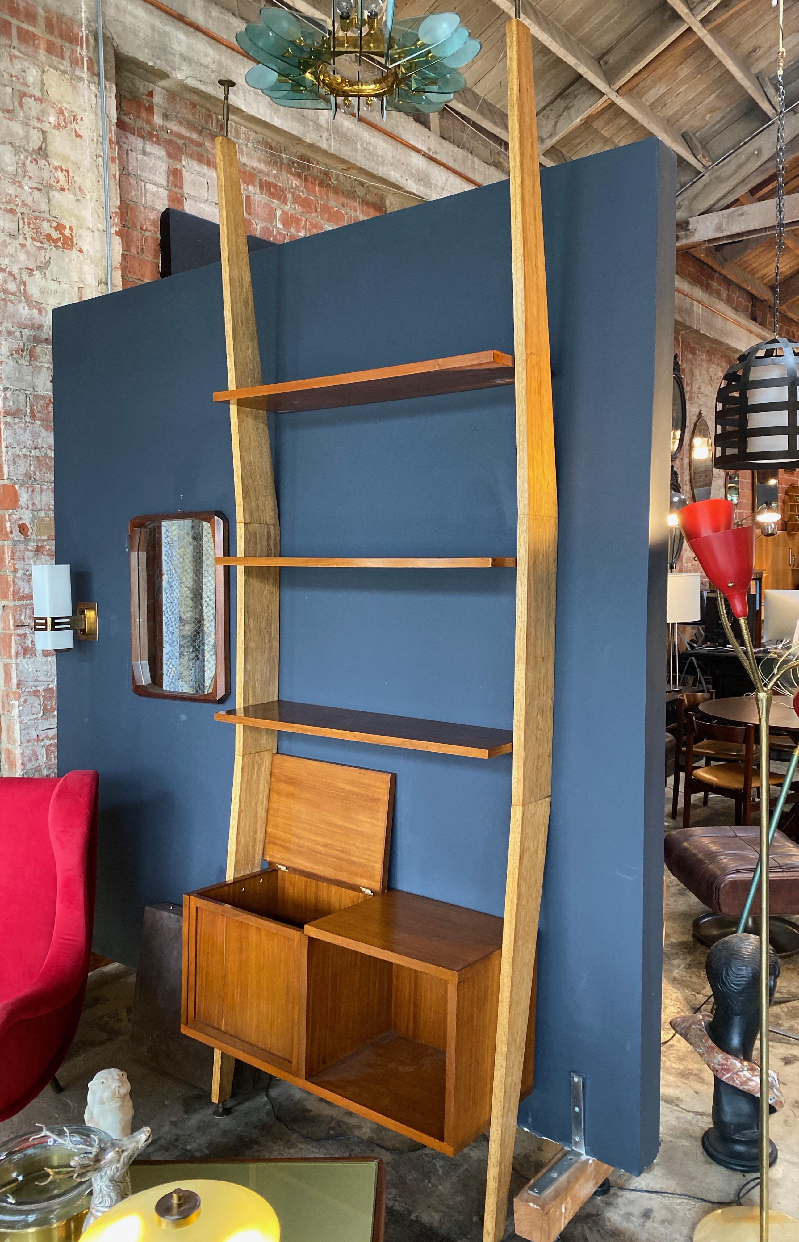 A particular shape for this bookshelf with brass adjustable feet designed by the architect Augusto Romano in 1950s.
It can be used also as a room divider or simply as a wall bookshelf. Better.
The lower body has two compartments one closed and
