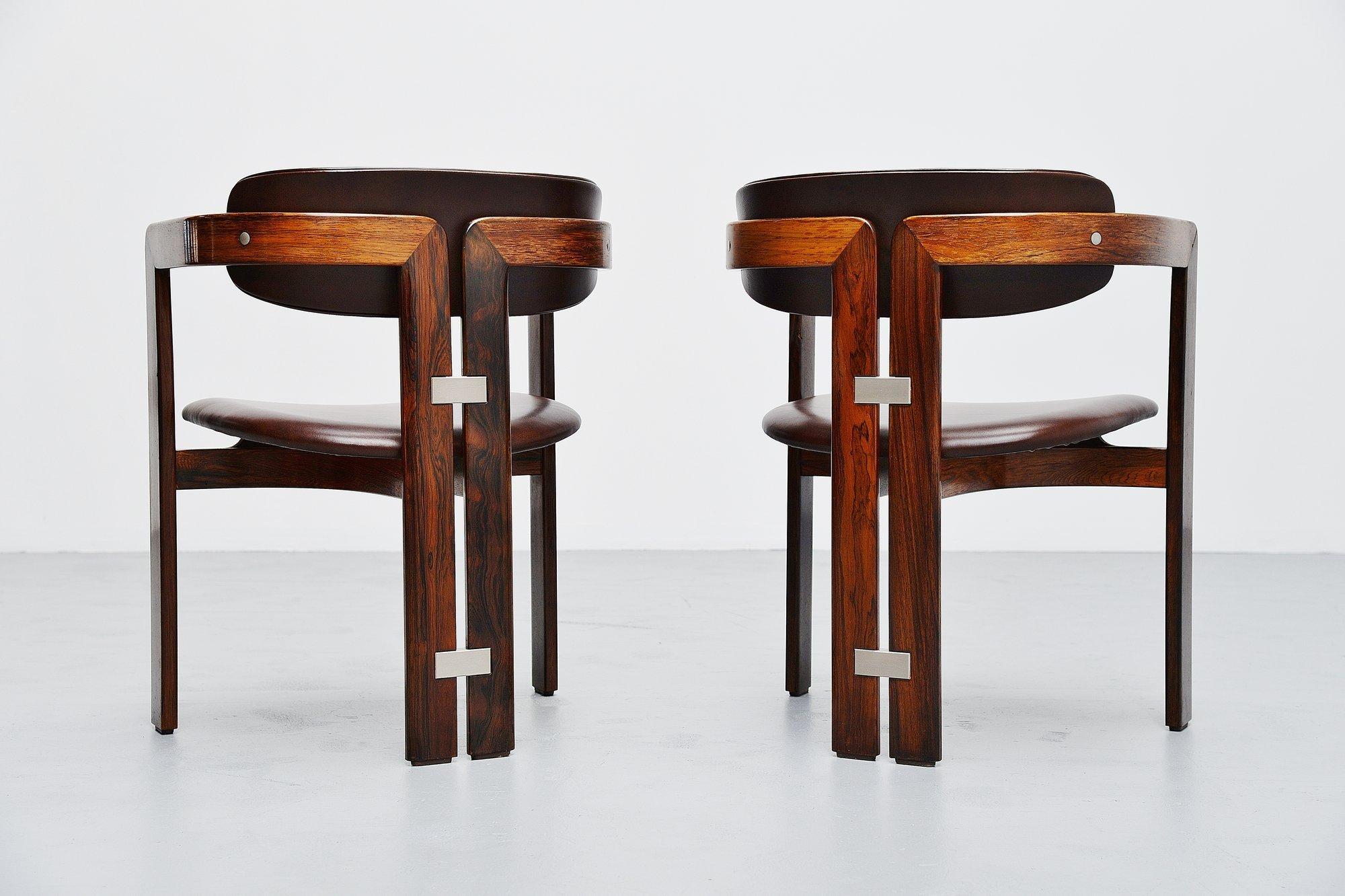 Étonnante paire de fauteuils conçue par Augusto Savini et fabriquée par Pozzi:: Italie 1965. Ces cartes ont des cadres en bois de rose massif et des sièges et dos en cuir brun en excellent état. Des chaises de forme très agréable et des sièges