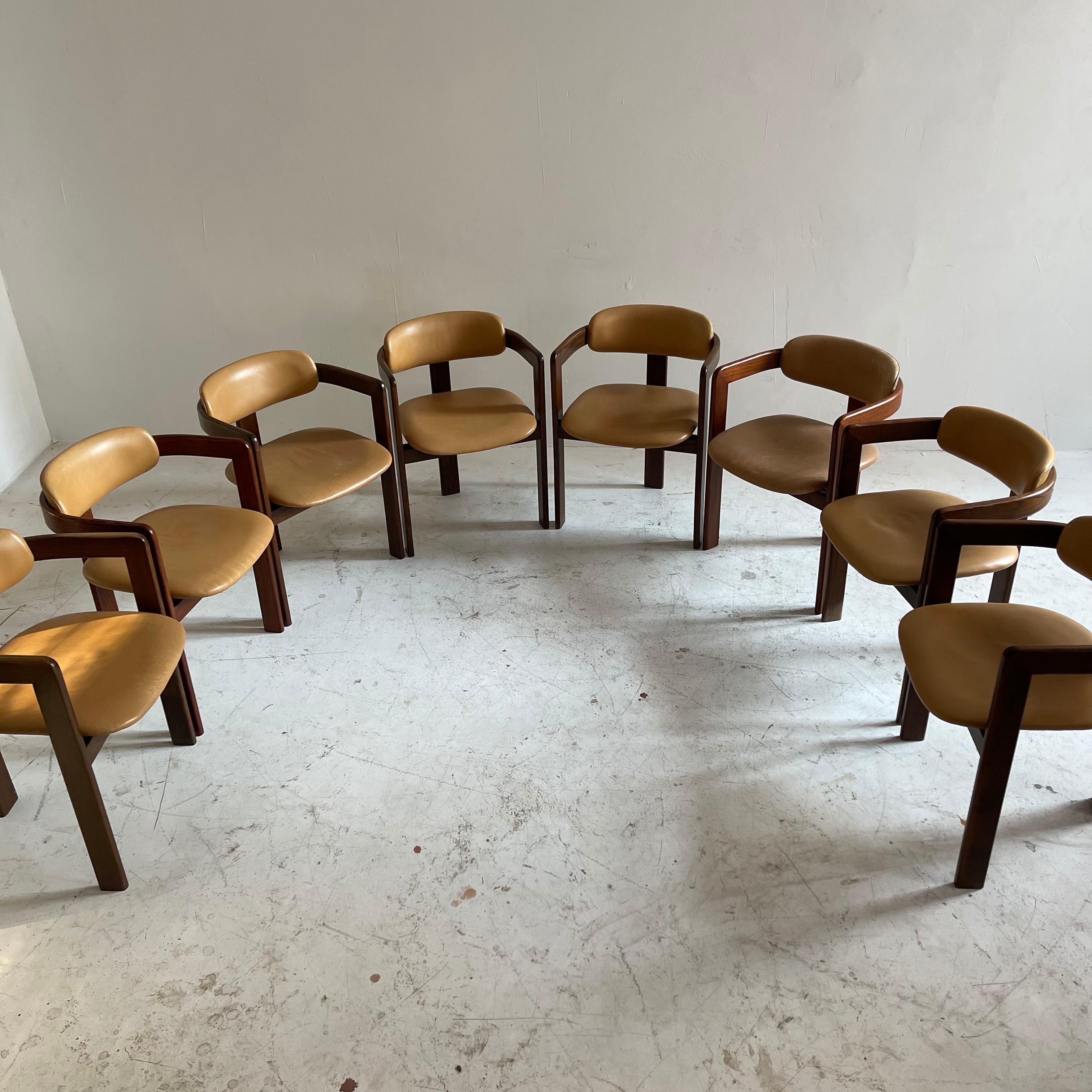 Mid Century Modern Augusto Savini Pamplona style cognac leather armchairs made in Switzerland 1970s. What an outstanding opportunity to own this fantastic set of eight arm chairs. Such an amazing set is very hard to find, but thankfully, we just did