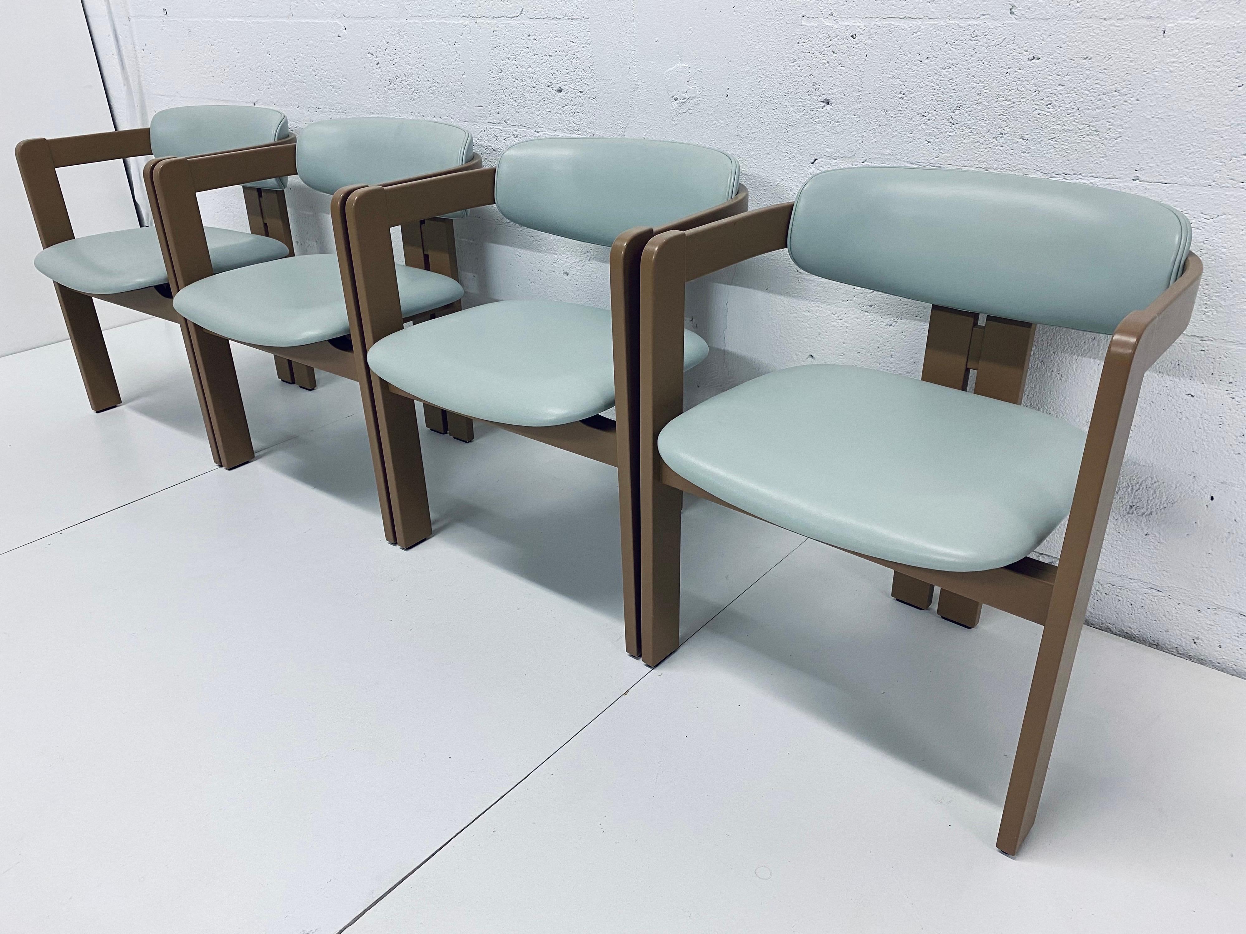 Set of four light turquoise leather and tan lacquered wood frame dining chairs inspired by Augusto Savini and manufactured for Pozzi, Italy.  These chairs are manufactured by Pozzi and maintain the original fabric backing but have a few design